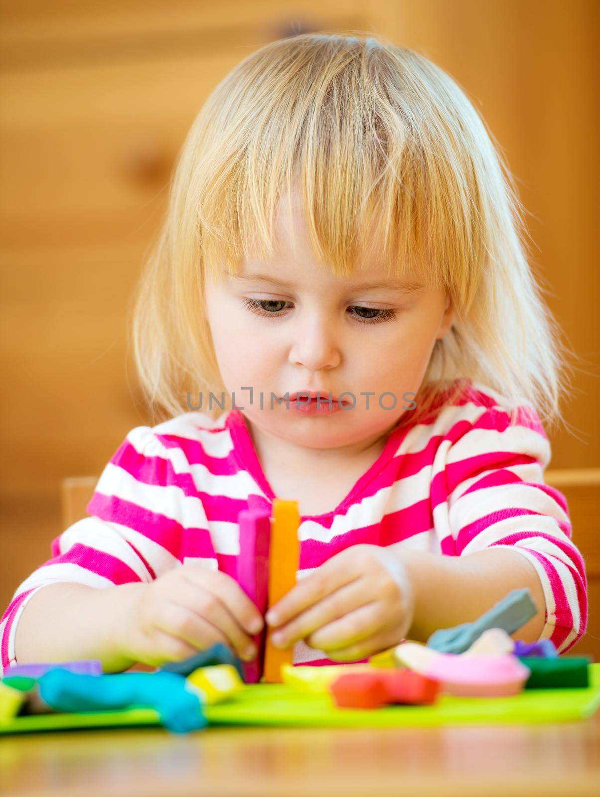 Little girl playing with plasticine by GekaSkr