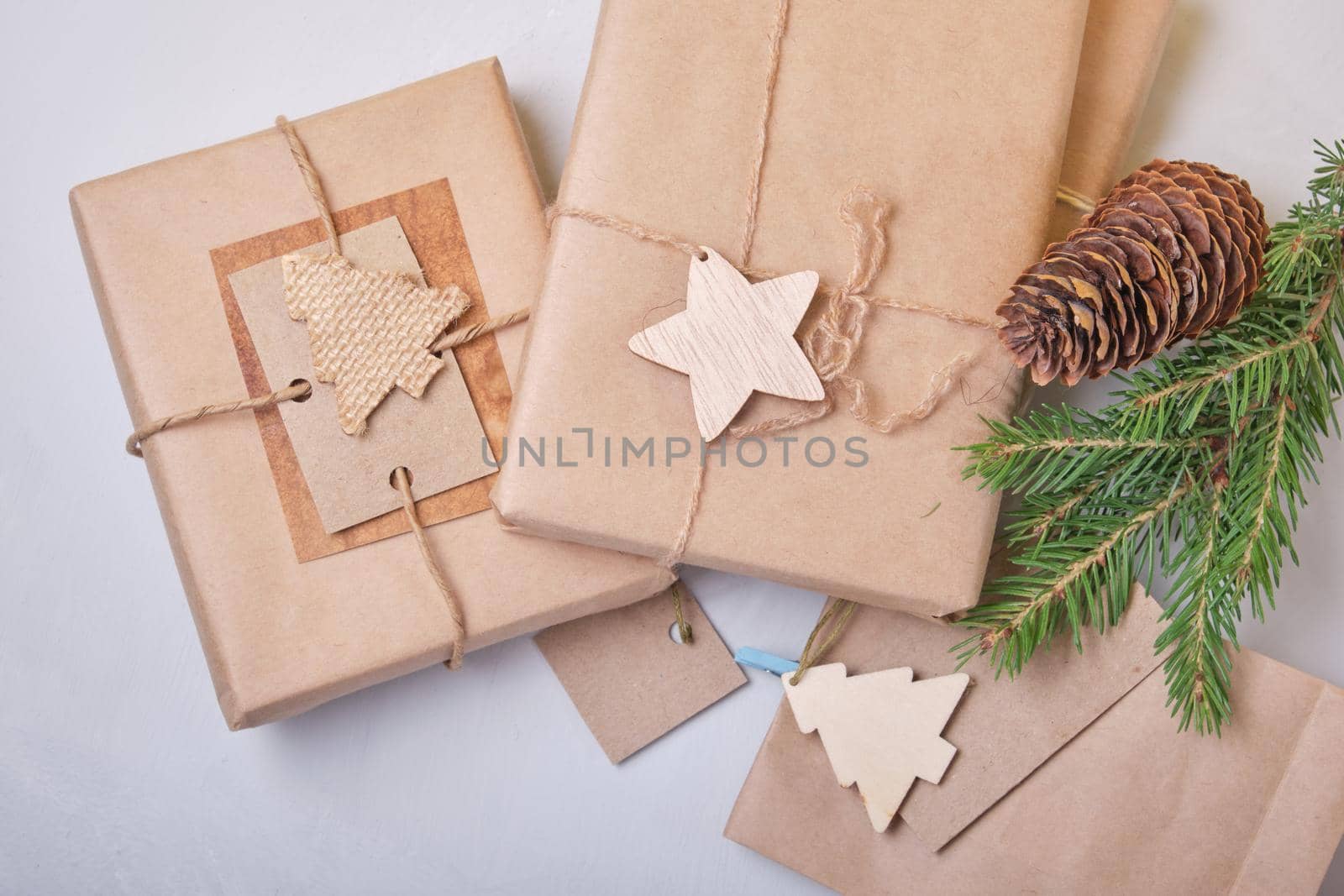 several boxes of gifts packed in eco paper on the table, zero waste lifestyle concept, packaging for DIY gifts, top view, gray background, eco christmas by natashko