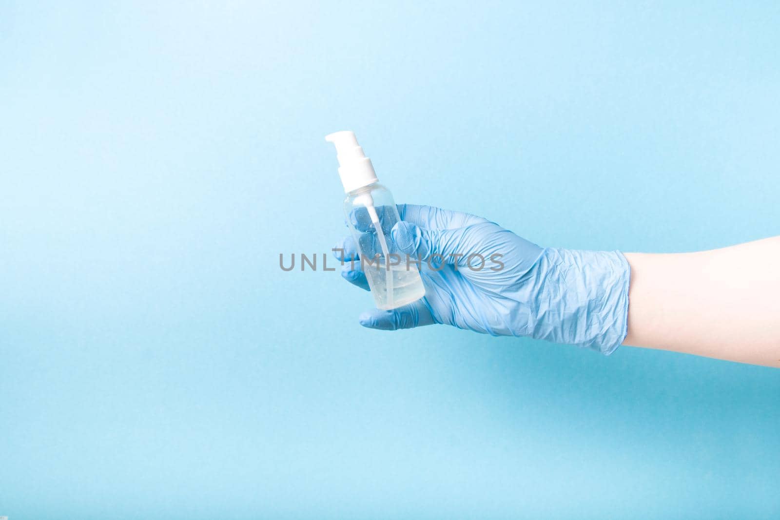 hand in a blue disposable medical glove holds antiseptic gel, hygiene and disease prevention, antiviral measures, quarantine 2020 by natashko