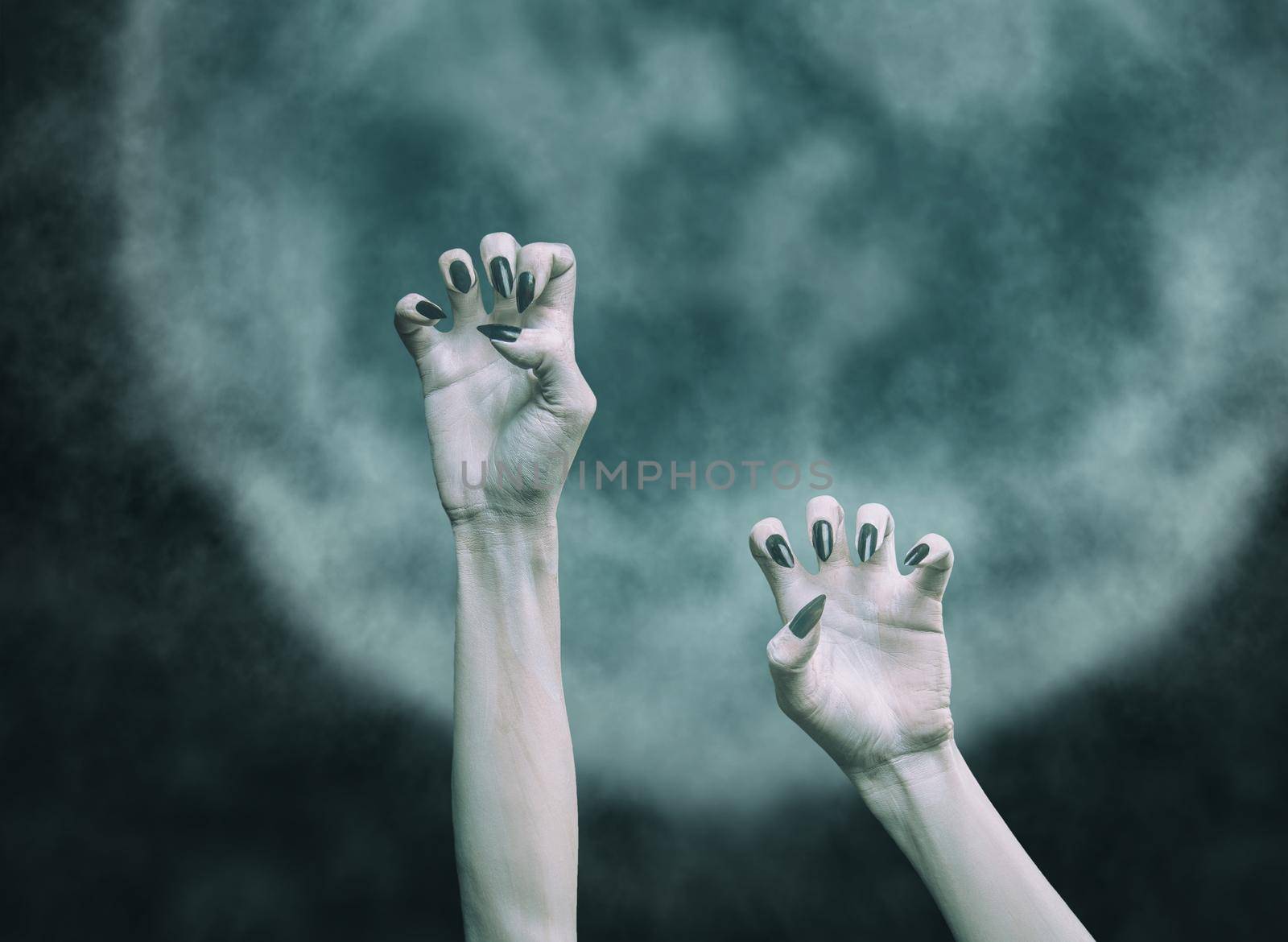 Scary hands of a dead man on background of moon. by alexAleksei