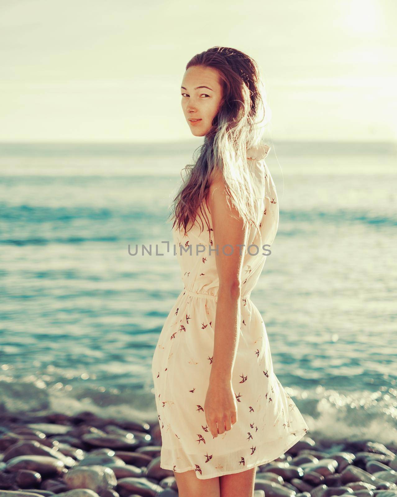 Young woman walking on beach by alexAleksei
