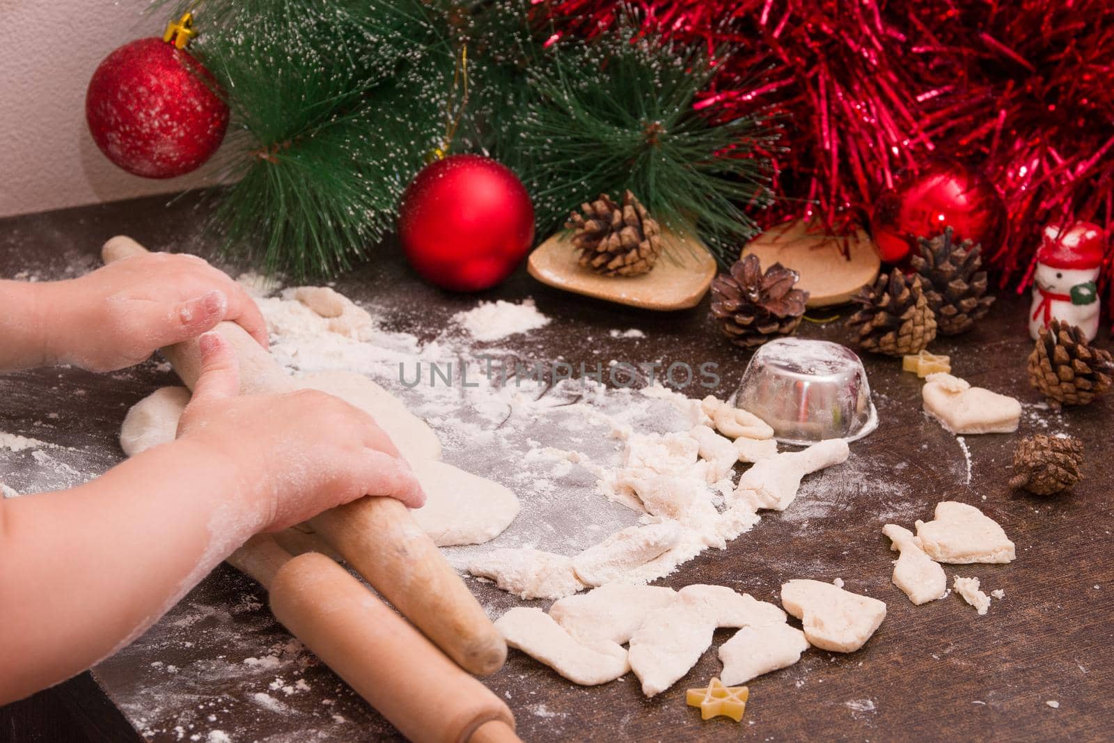 children hands roll out the dough for Christmas cookies, New Year's background, copy space