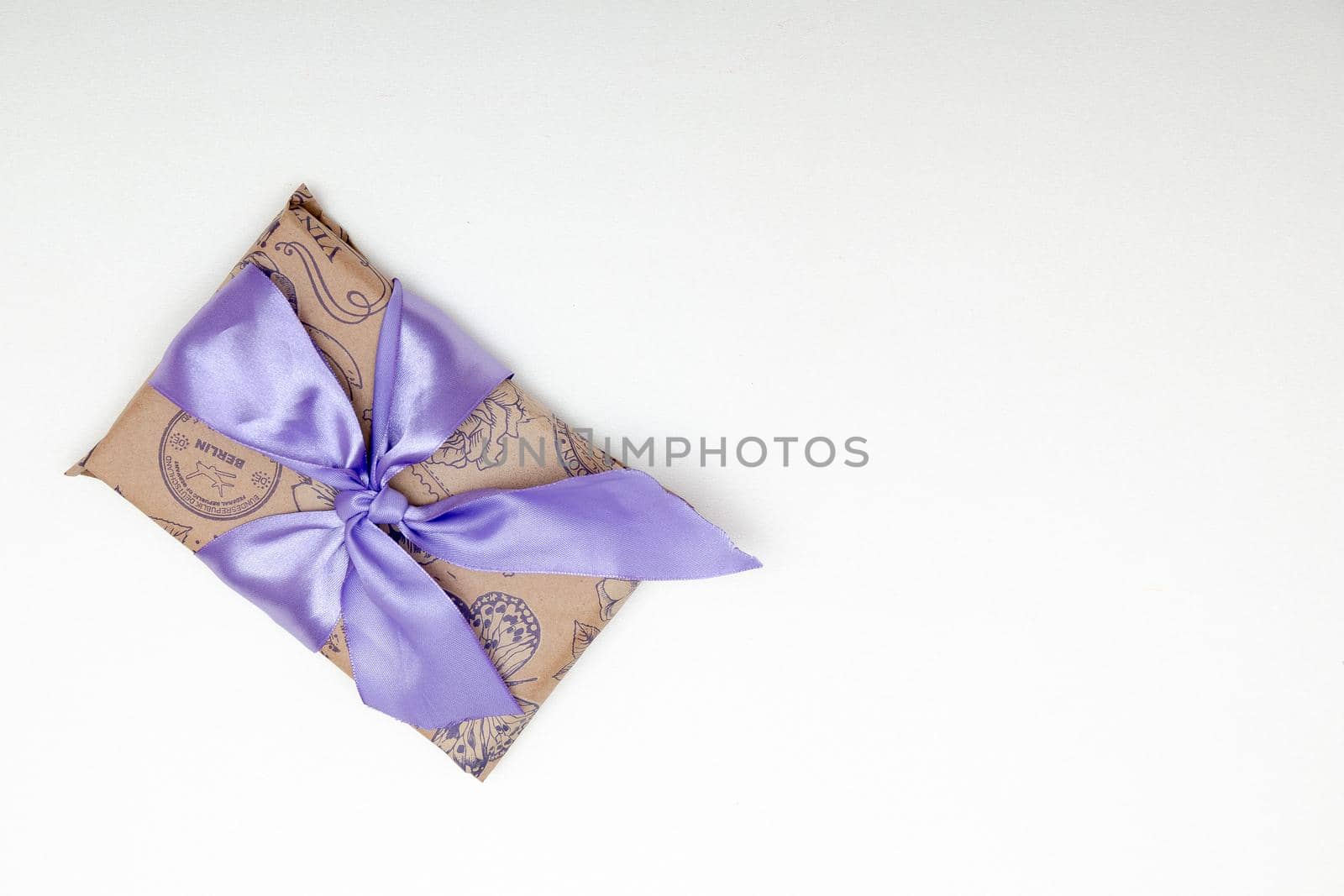 present on a white background with lilac ribbon bow brown paper by natashko