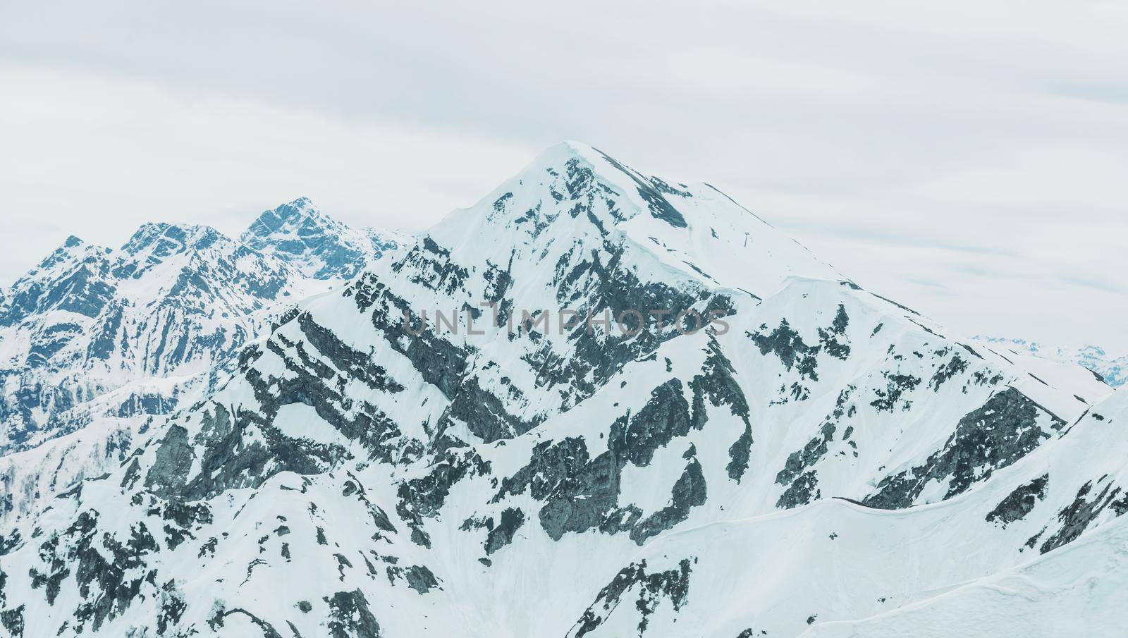 Beautiful Caucasian mountains in the snow in winter. Peaks of mountains