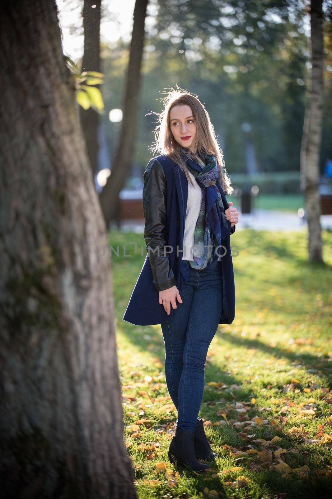 Beautiful girl with dark lipstick standing in the park. Natural daylight. Autumn. Fall season