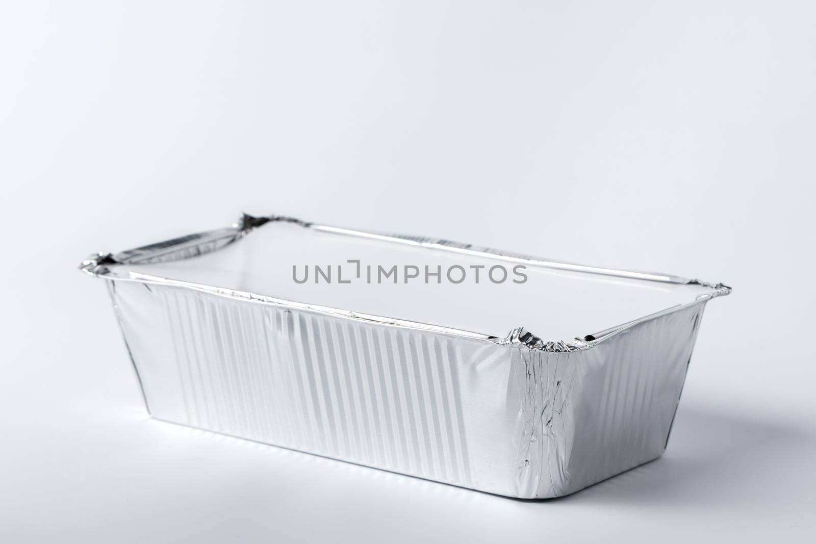 Foil food box with takeaway meal on white background close up