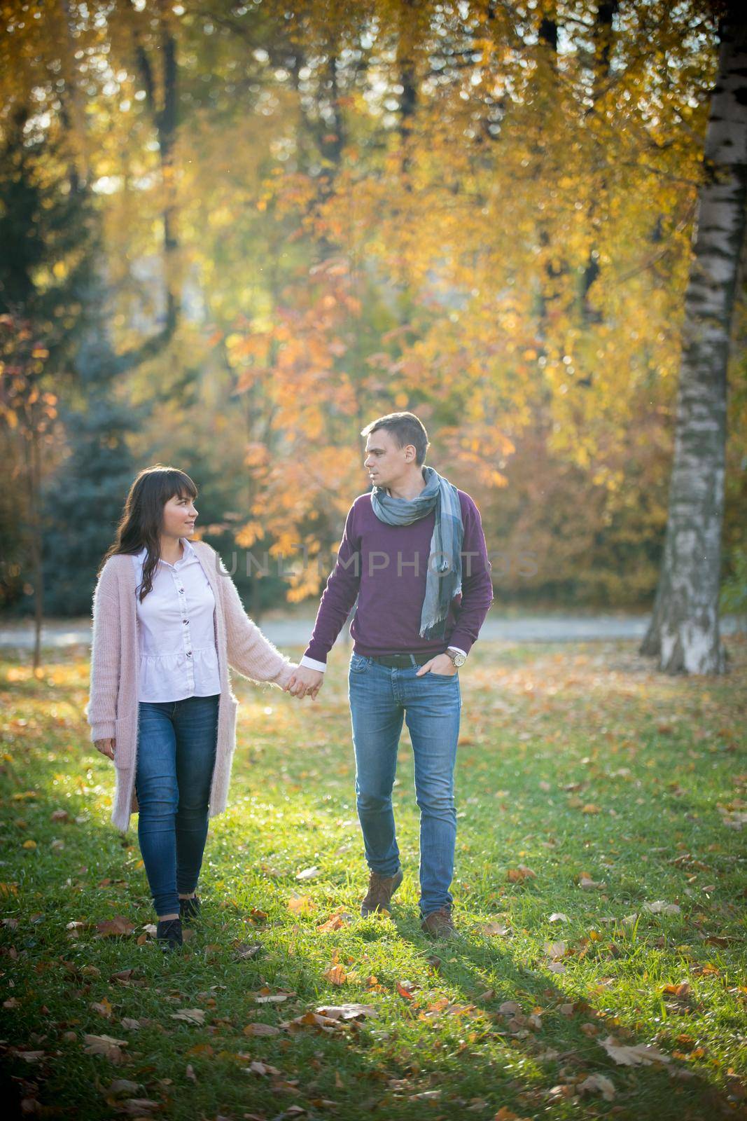 Loving couple walk holding hands in the autumn park by Studia72