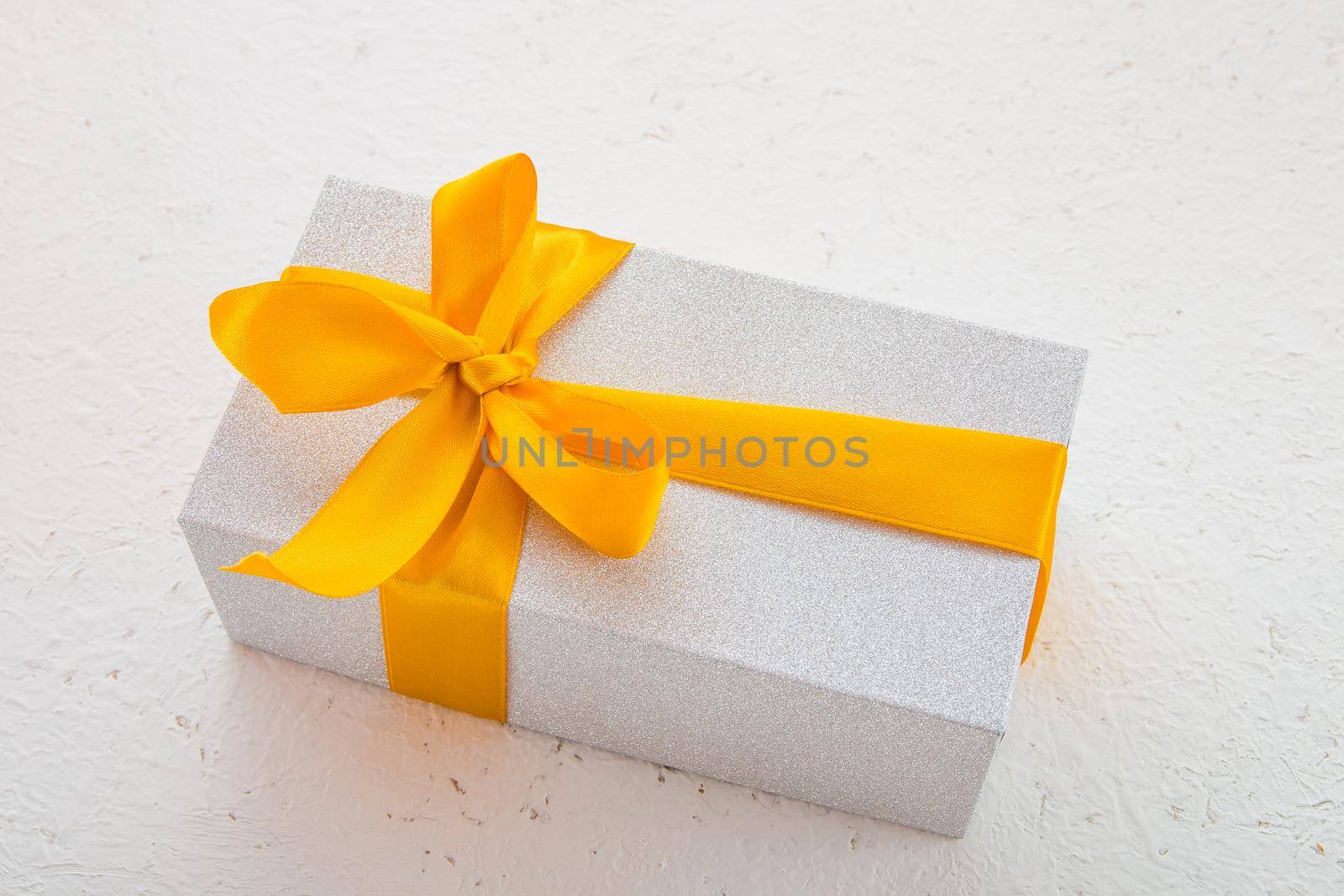 shiny gift box with a gold bow on a white background