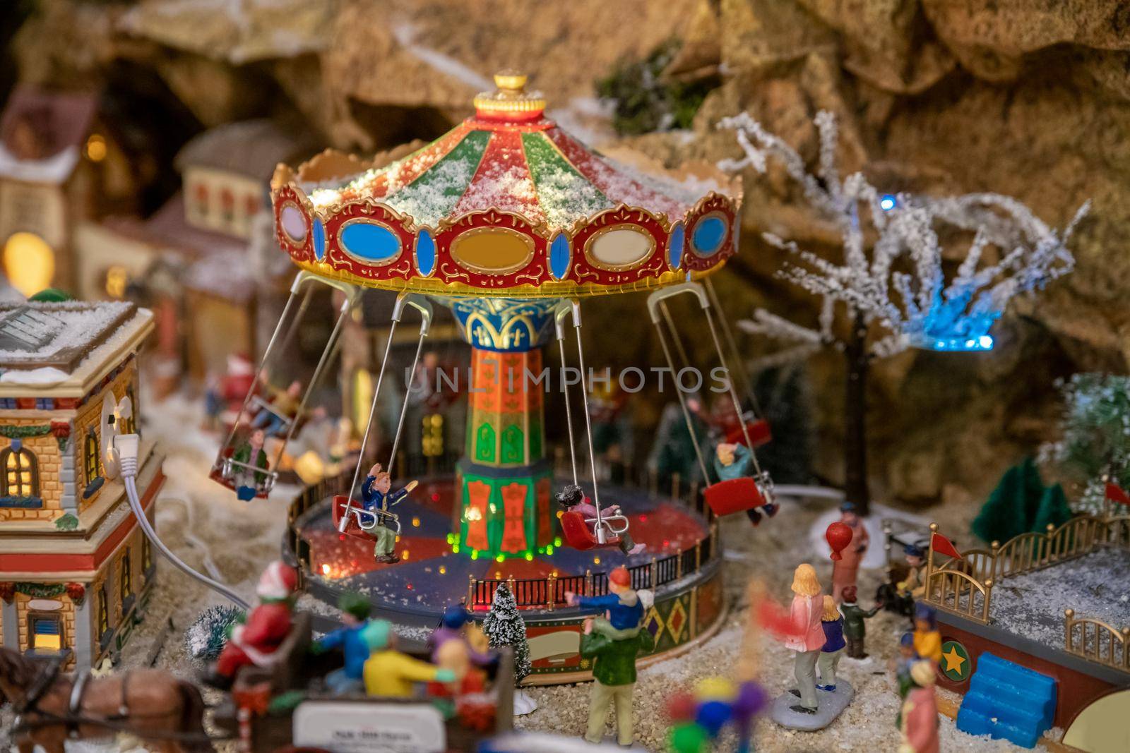 Amusement park in miniature with carousels in winter with figurines