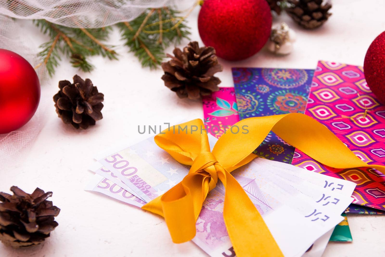 christmas gifts new year, money, euro bills, gift box, gold ribbon, christmas toys, spruce branches, top view, copy space by natashko