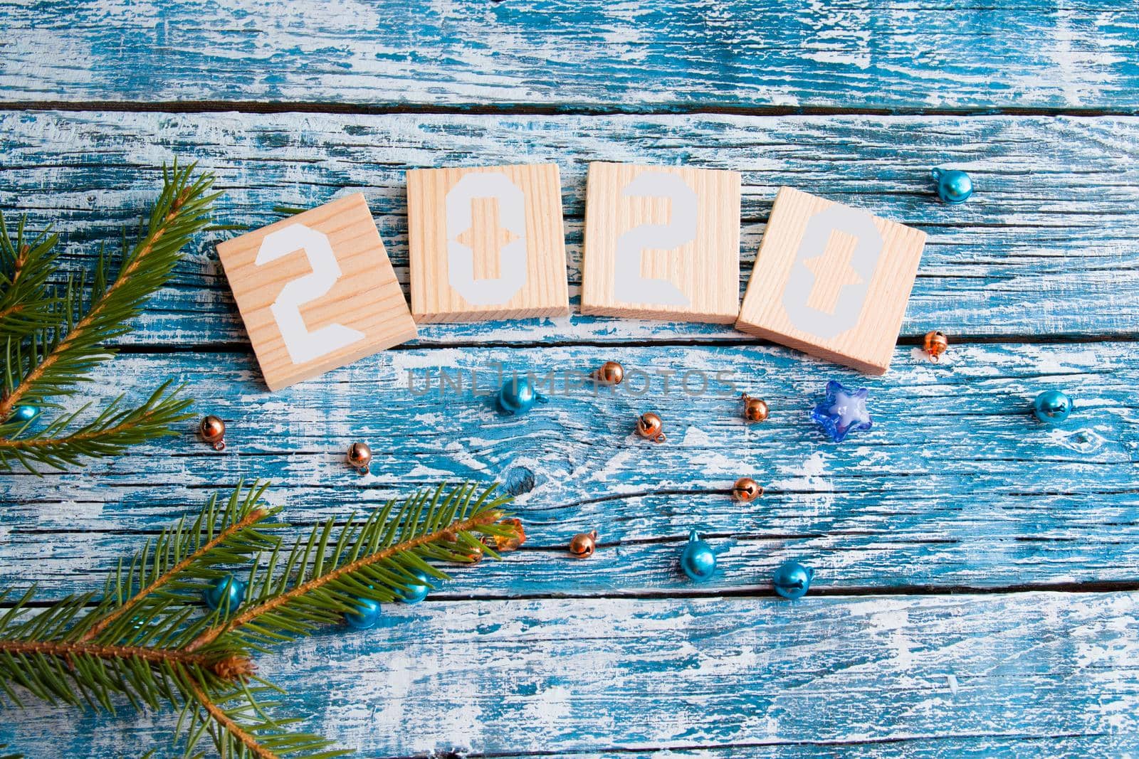 wooden squares for text, new year 2020, spruce branch, shiny beads, blue wooden background by natashko