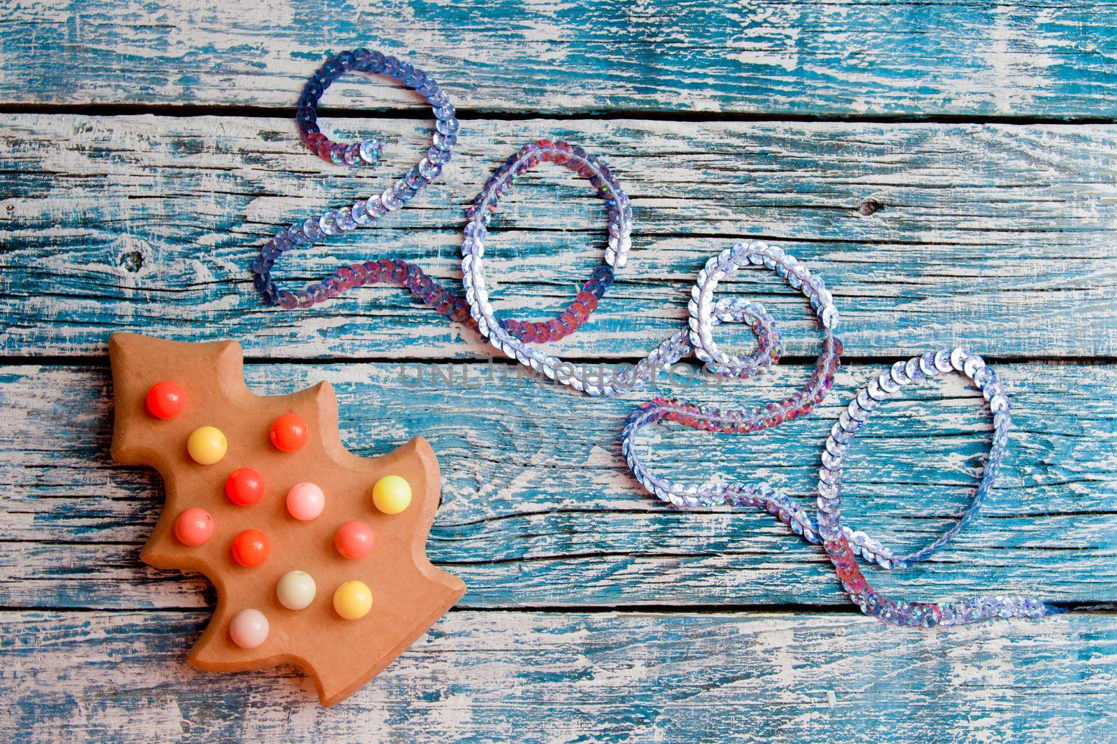 2020 inscription of sequins, wooden toy fir, blue background, new year, top view by natashko