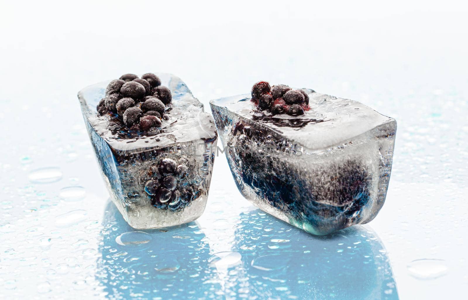Ice cubes with frozen berries inside close up. High quality photo