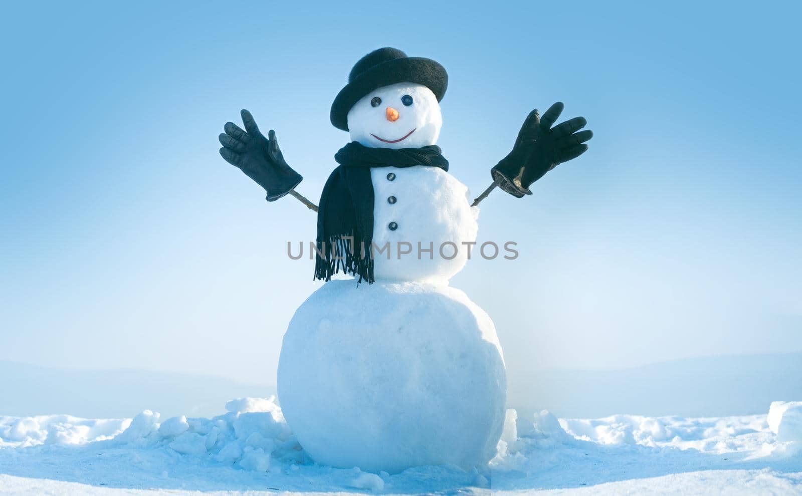 Snowman with hat and scarf in winter outdoor. Snowman gentleman in winter black hat, scarf and gloves. Xmas or christmas party, copy space. by Tverdokhlib