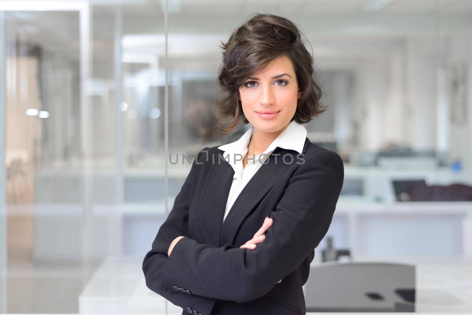 Business woman in an office. Crossed arms by javiindy