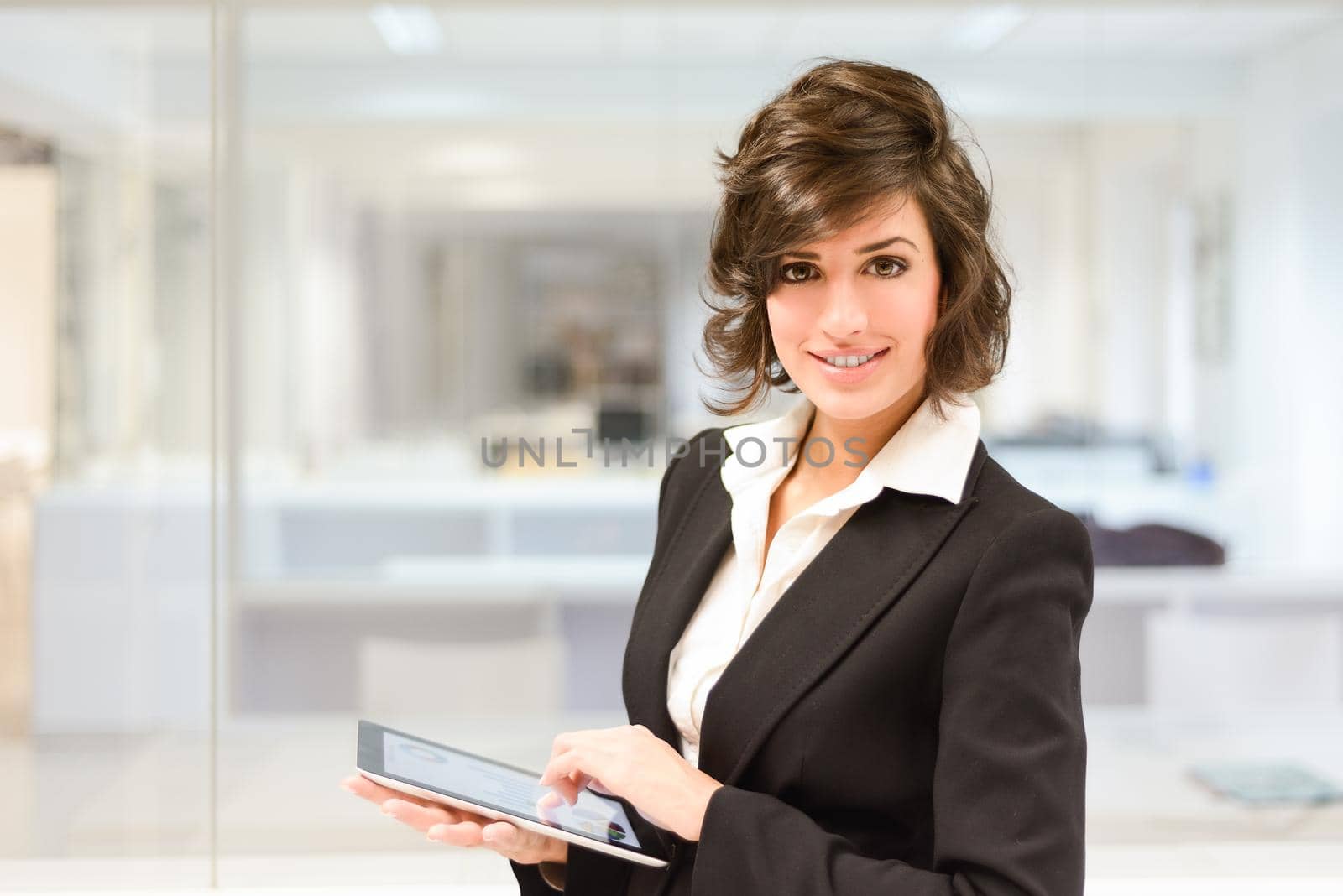 Young pretty business woman with tablet computer in the office by javiindy