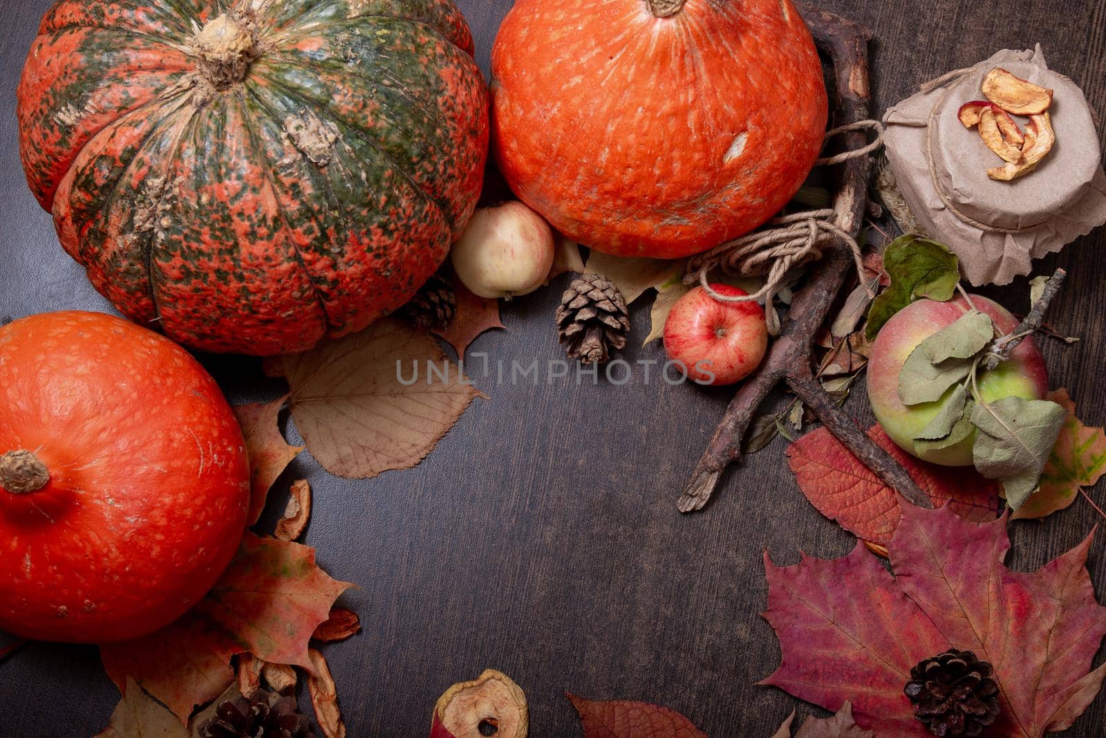 autumn mood, pumpkins, leaves, apples and dried fruits on a dark brown wooden table, copy space, top view by natashko