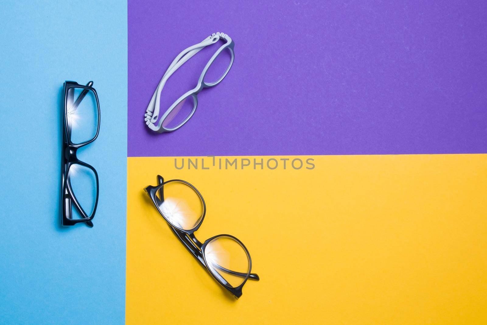 a few glasses on a colorful background, top view, buying glasses, a store of glasses and frames for glasses, children's glasses and glasses for adults by natashko