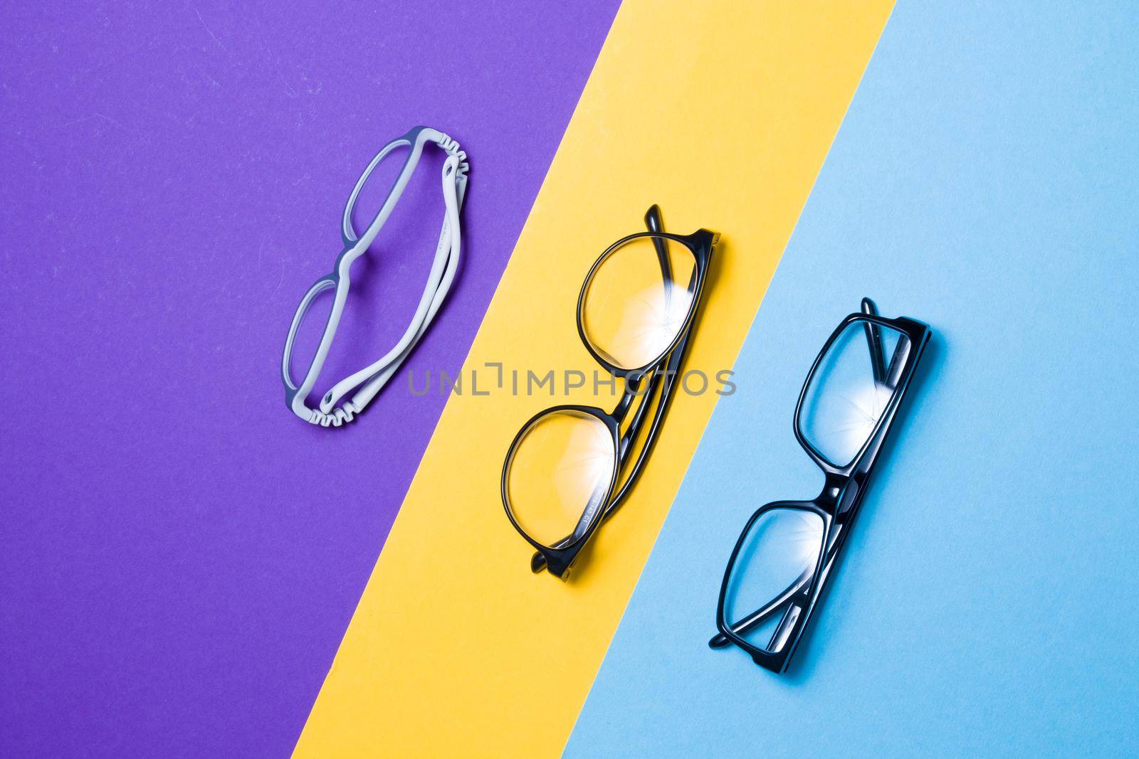 several different glasses on a colorful background, top view, buying glasses, a store of glasses and frames for glasses, children's glasses and glasses for adults