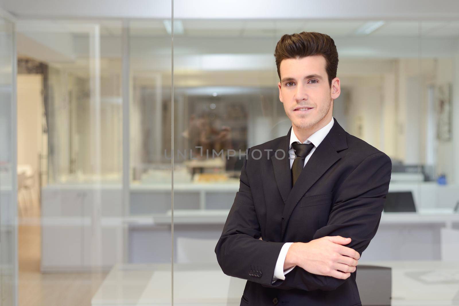 Handsome young businessman in an office by javiindy