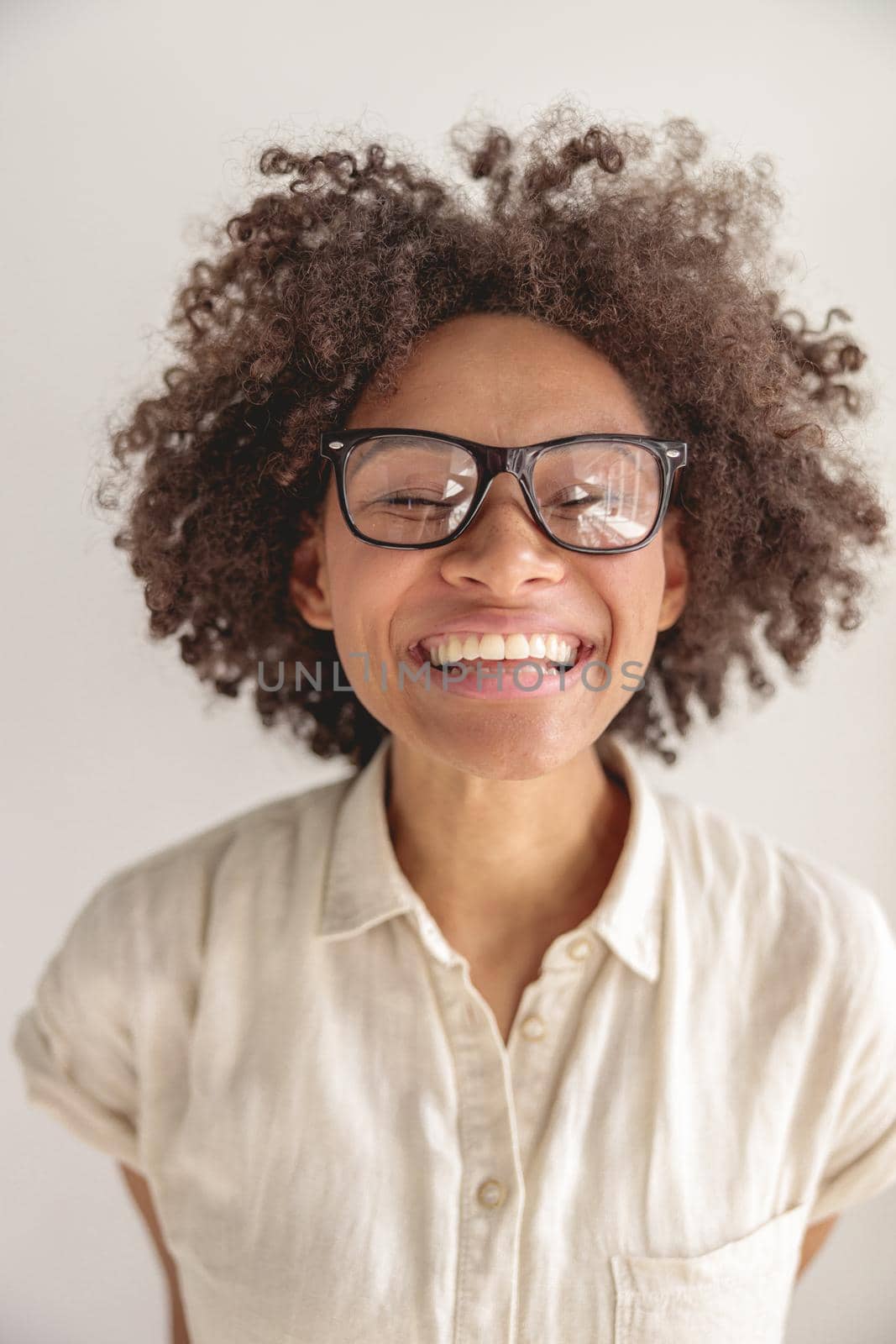 Portrait of smiling pretty lady in glasses looking at camera, isolated on grey background