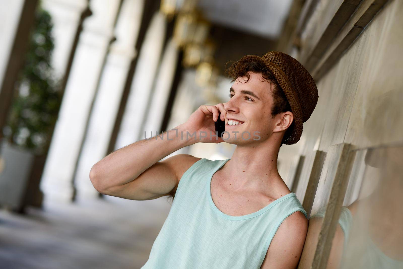 Portrait of an attractive young man wearing hat talking on the mobile phone