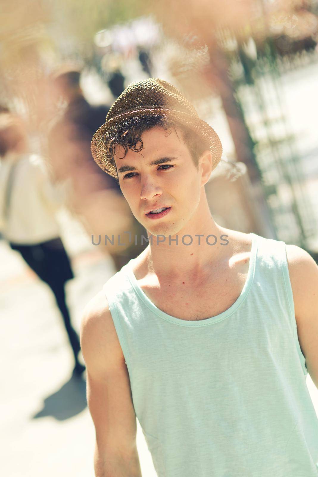 Portrait of a young handsome man, model of fashion, with modern hairstyle in urban background