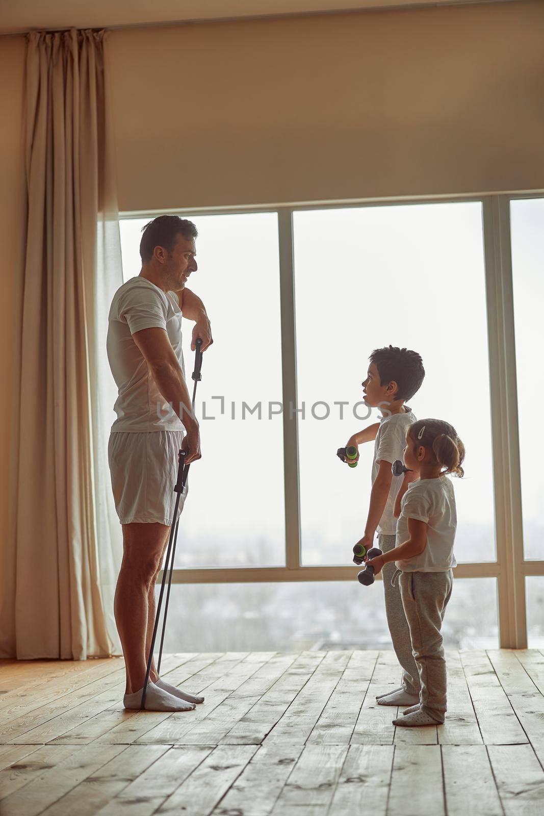 Father training together with daughter and son indoors by Yaroslav_astakhov
