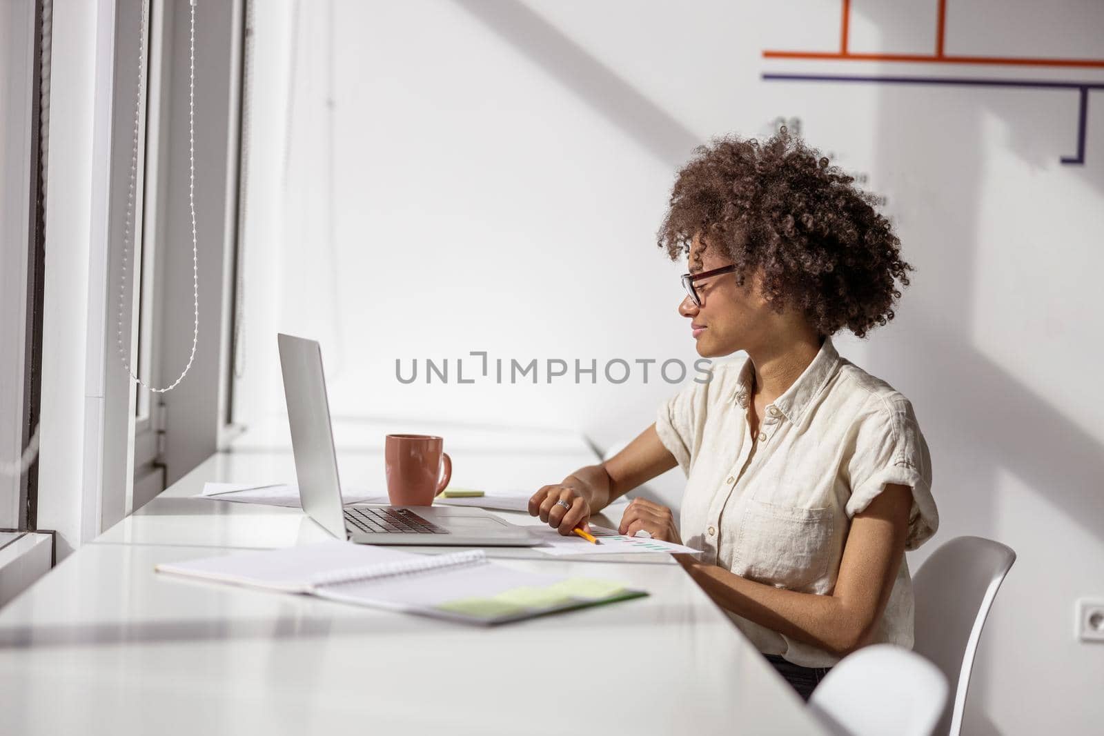 Smiling lady working with a report in a modern office by Yaroslav_astakhov