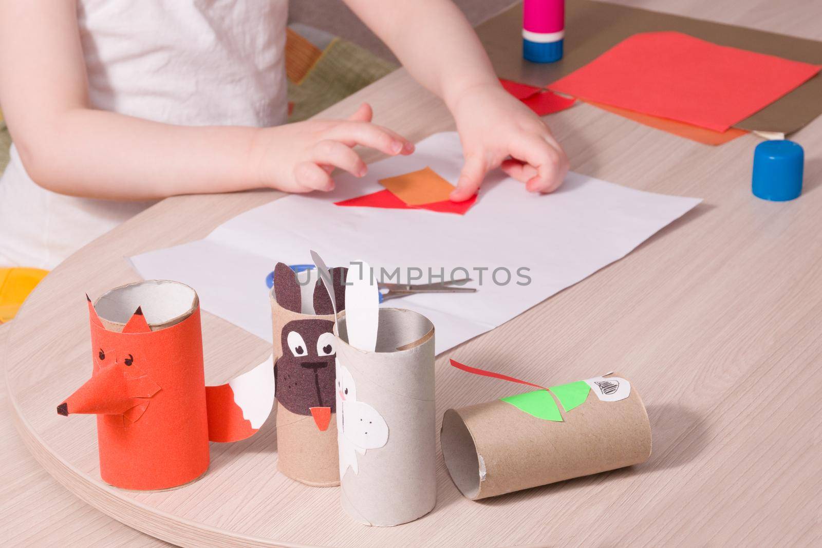 crafts from colored paper and toilet paper bushings, what to do with the child at home, development of imagination and fine motor skills of the hands, the child makes an application