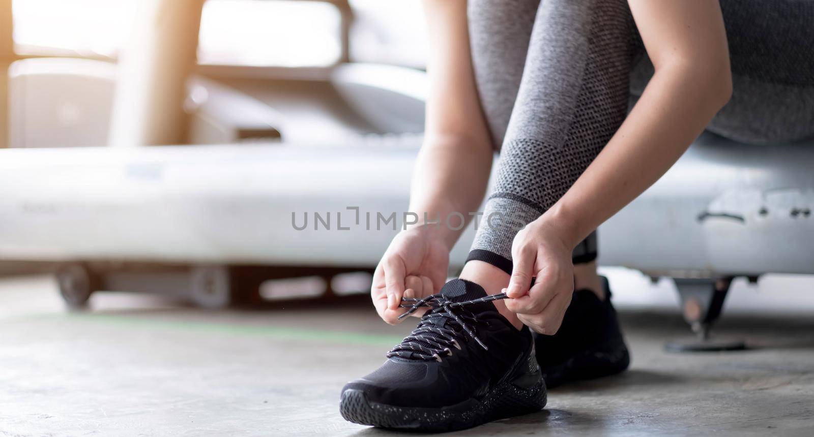 Sports Shoes. Woman Hands Tying Shoelaces On Fashion Sneakers by wichayada