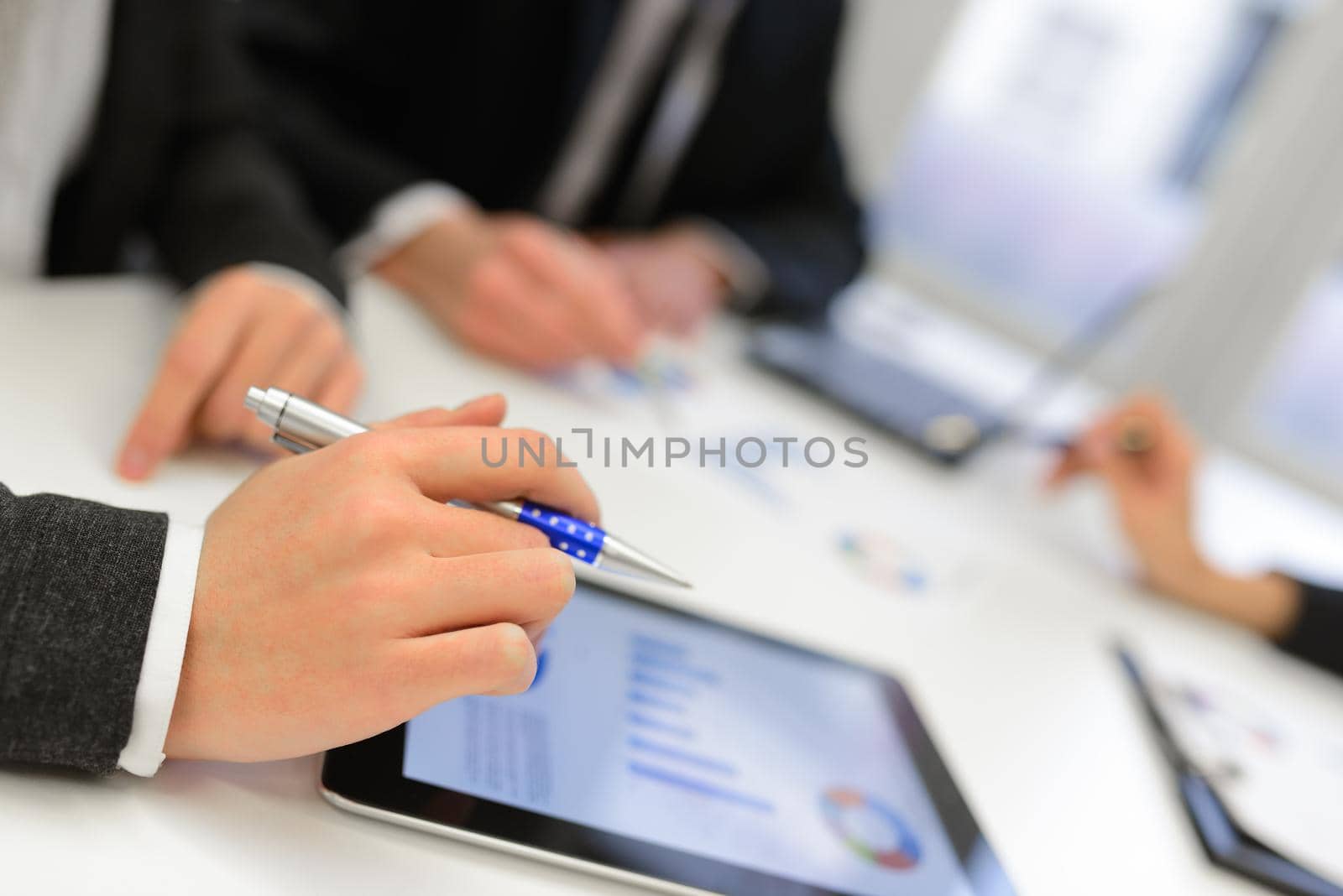 Close-up of a modern business team using tablet computer to work with financial data