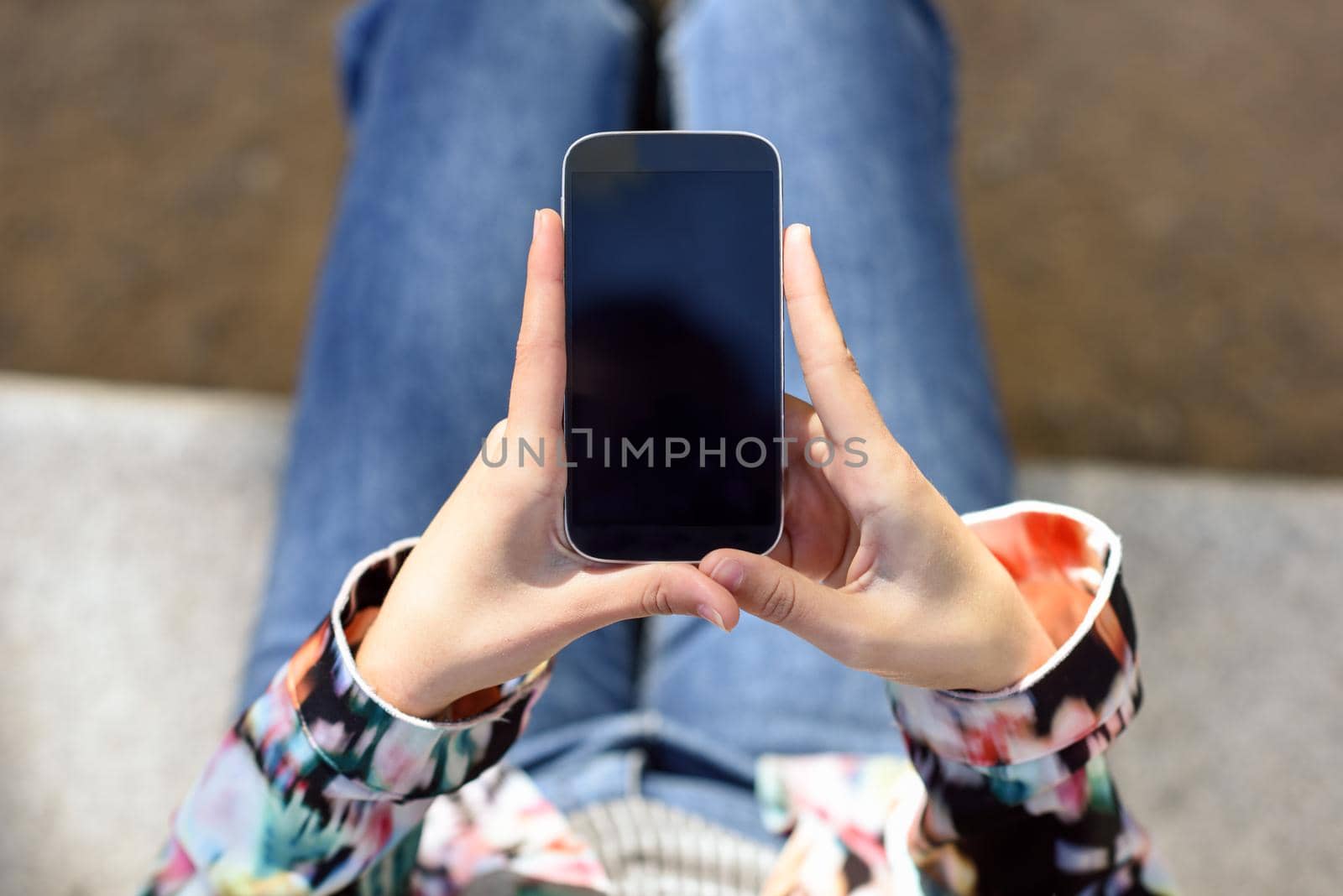 Young woman using a touchscreen smartphone wearing casual clothes