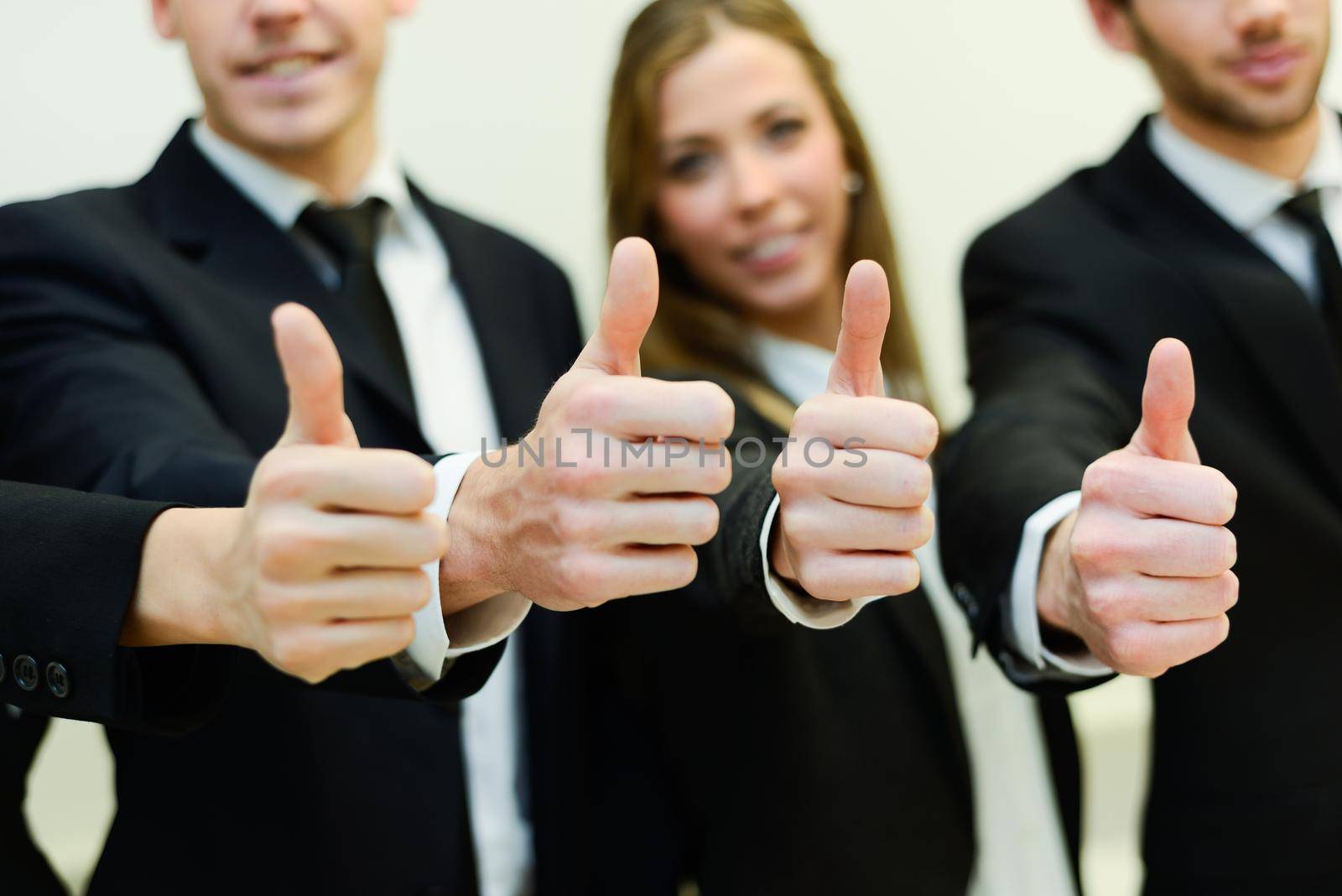 Close-up of business team holding their thumbs up