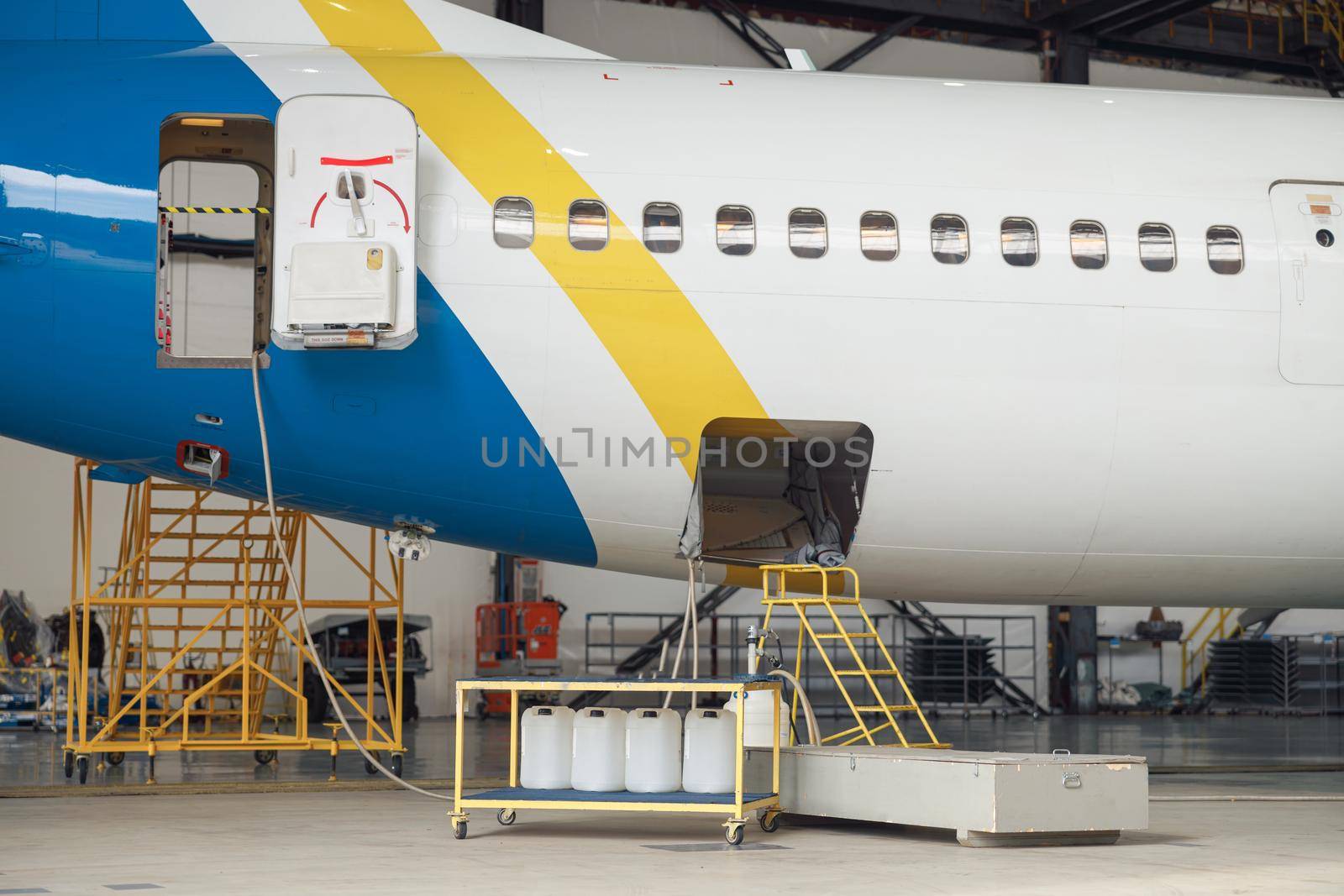 Passenger airplane on maintenance repair in airport hangar indoors in the daytime. Aircraft. Plane, shipping, transportation concept