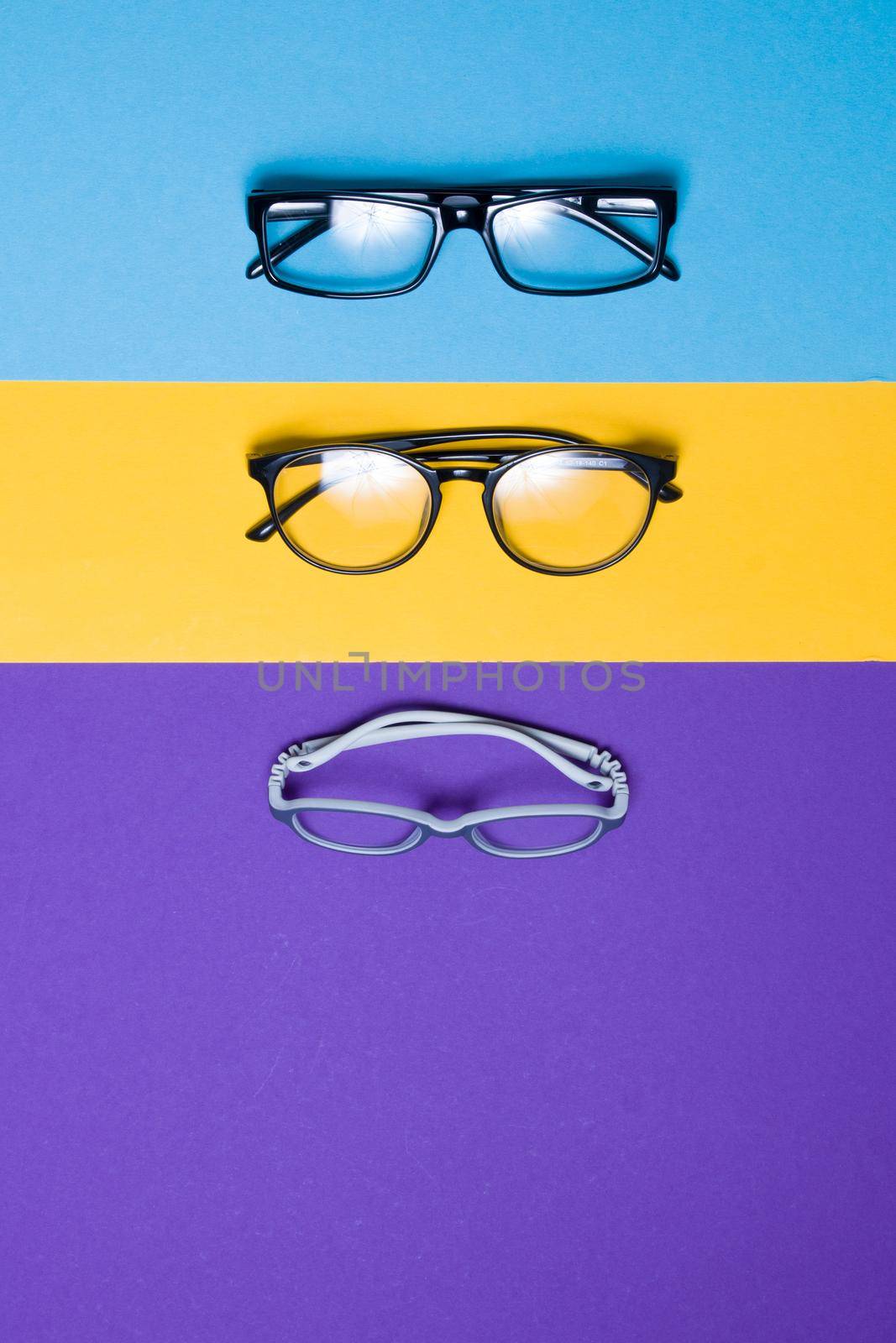 several different glasses on a colorful background, top view, buying glasses, a store of glasses and frames for glasses, children's glasses and glasses for adults