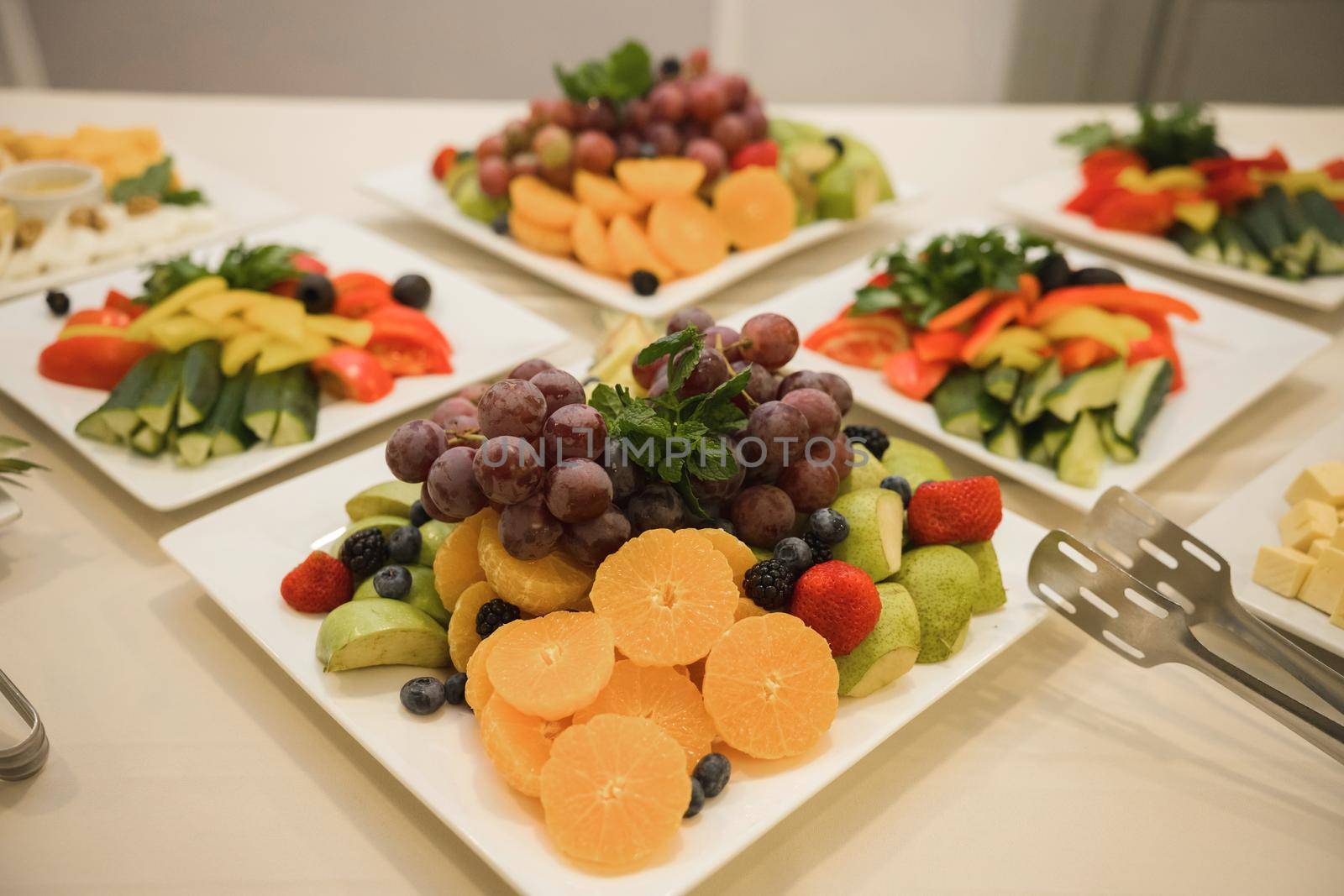 Portions of dietary salads from vegetables and fruits. Salads are on a wooden table with forks