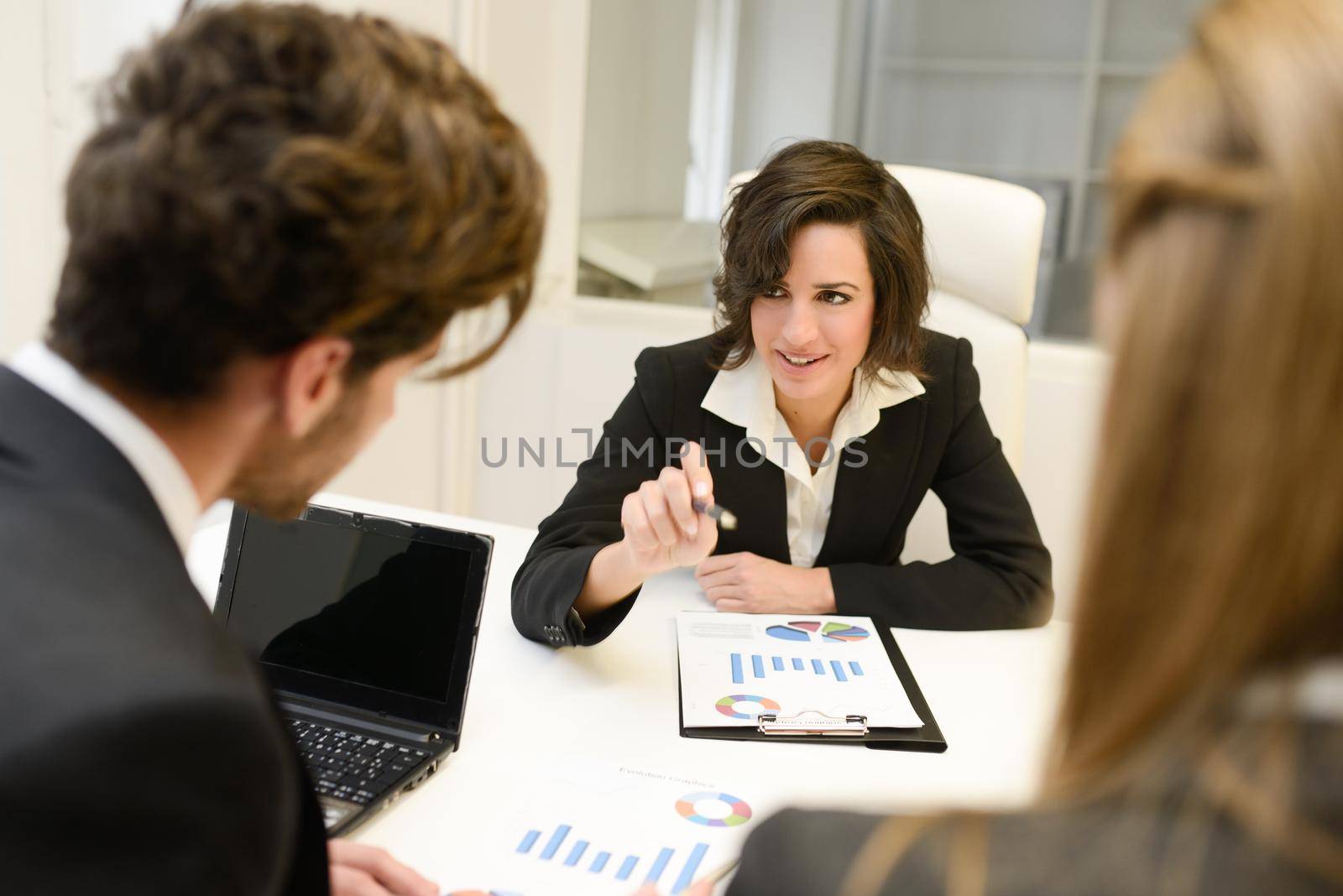 Image of business partners discussing documents and ideas at meeting. Woman leader wearing blazer