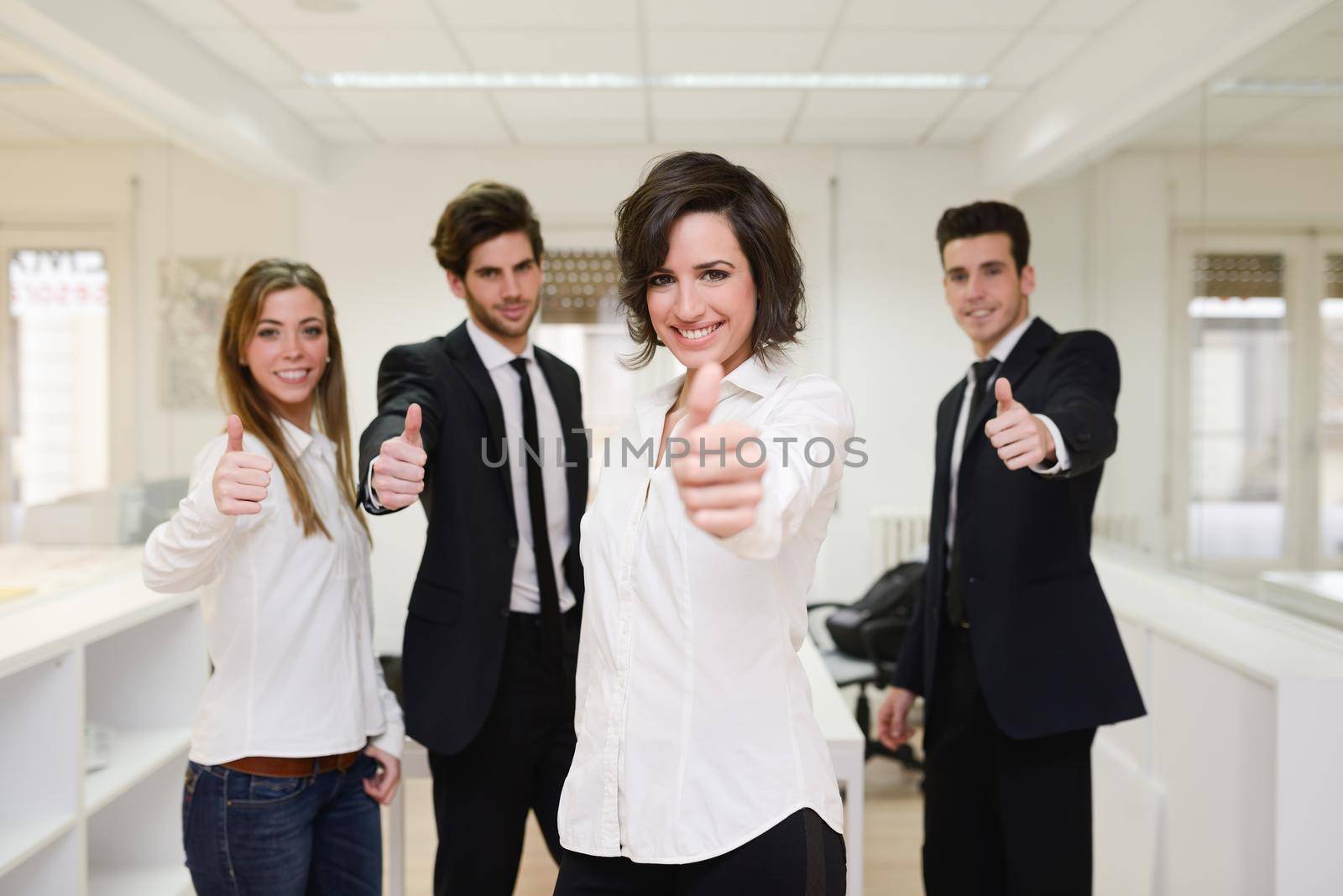 Portrait of cheerful business group giving thumbs up