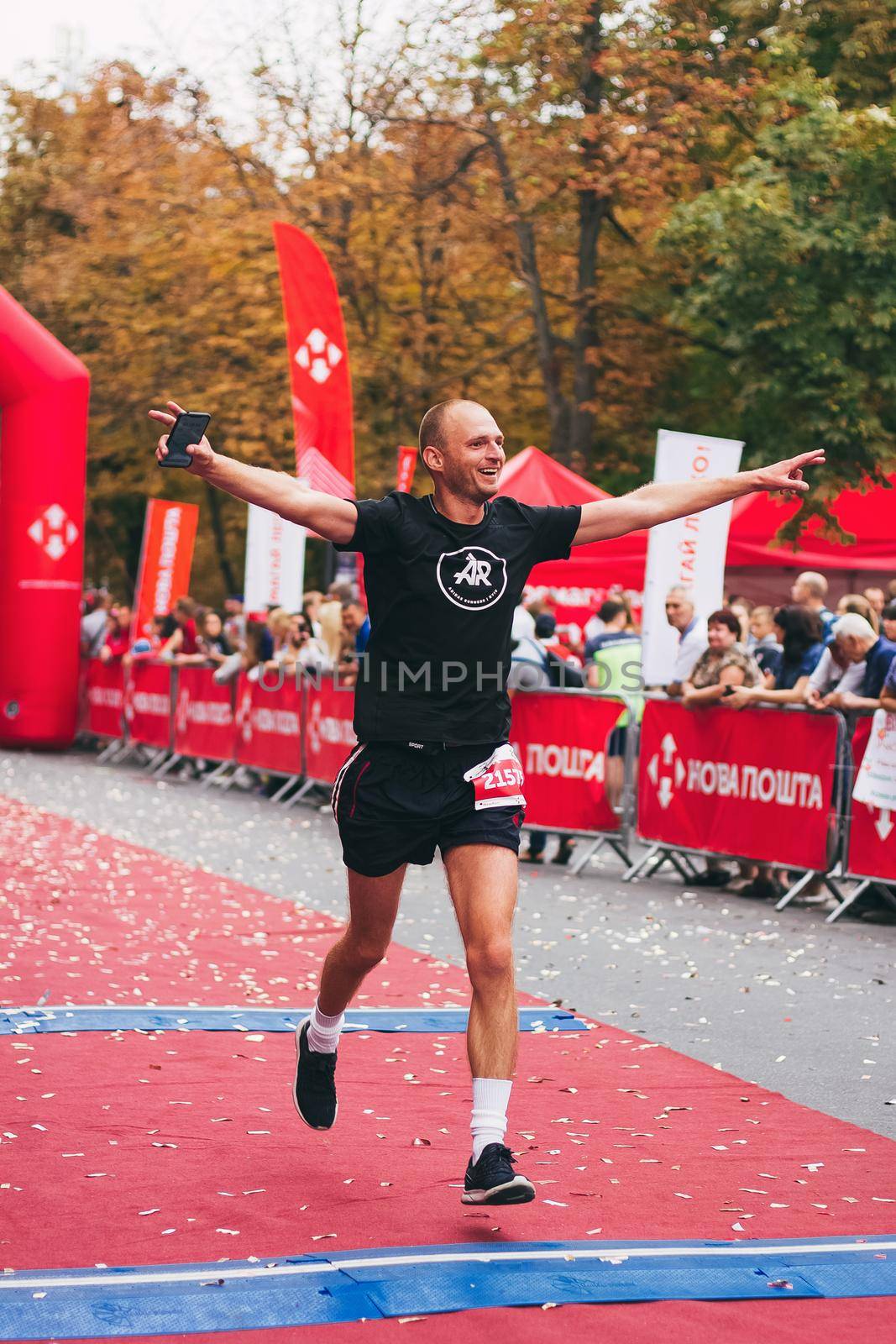 POLTAVA, UKRAINE - 1 SEPTEMBER 2019: A happy man reaches finish line during Nova Poshta Poltava Half Marathon by mmp1206