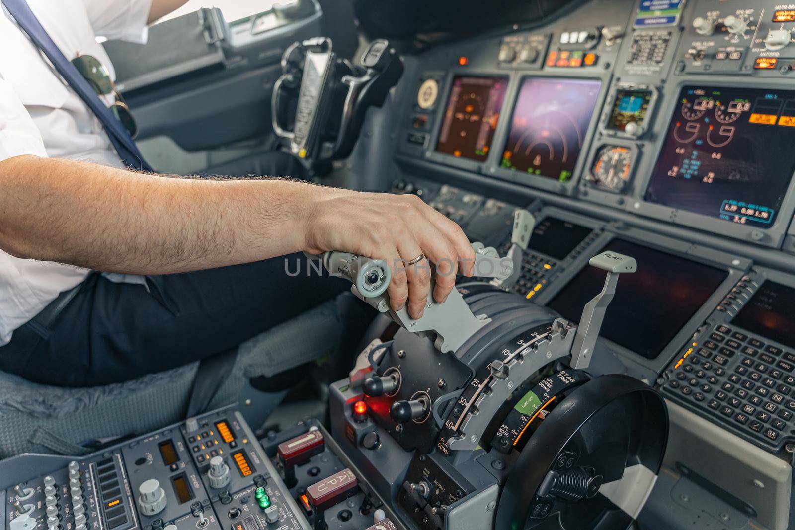 Cropped photo of pilot hand accelerating on the throttle in commercial airplane. Profession concept