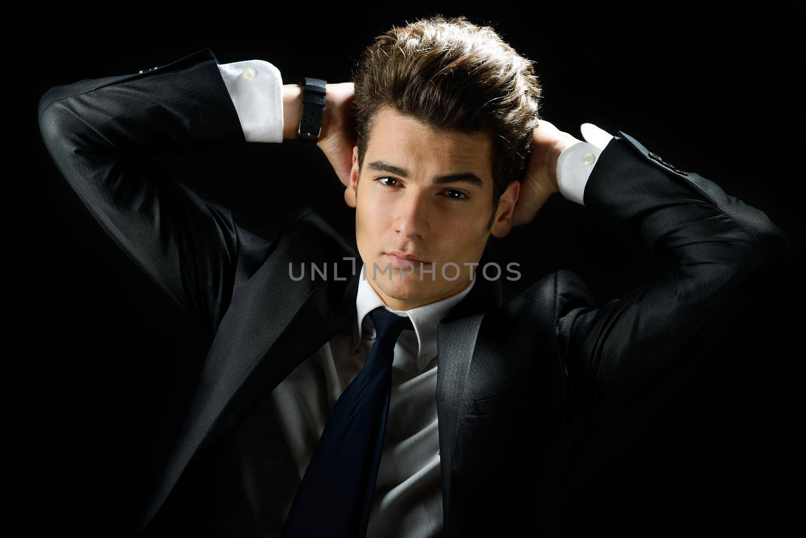 Portrait of a young businessman, isolated on black background