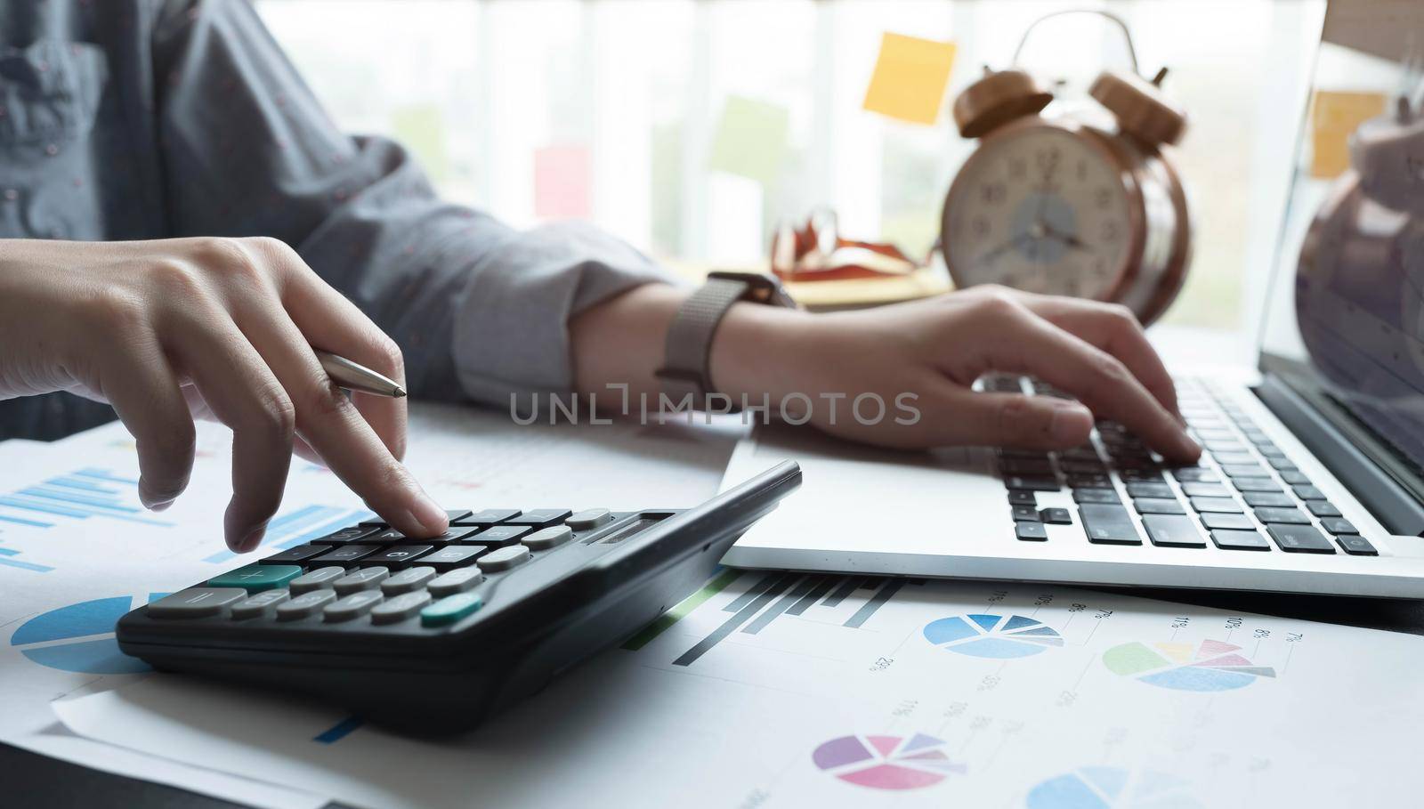 Close up Businesswoman using calculator and laptop for calaulating finance, tax, accounting, statistics and analytic research concept.