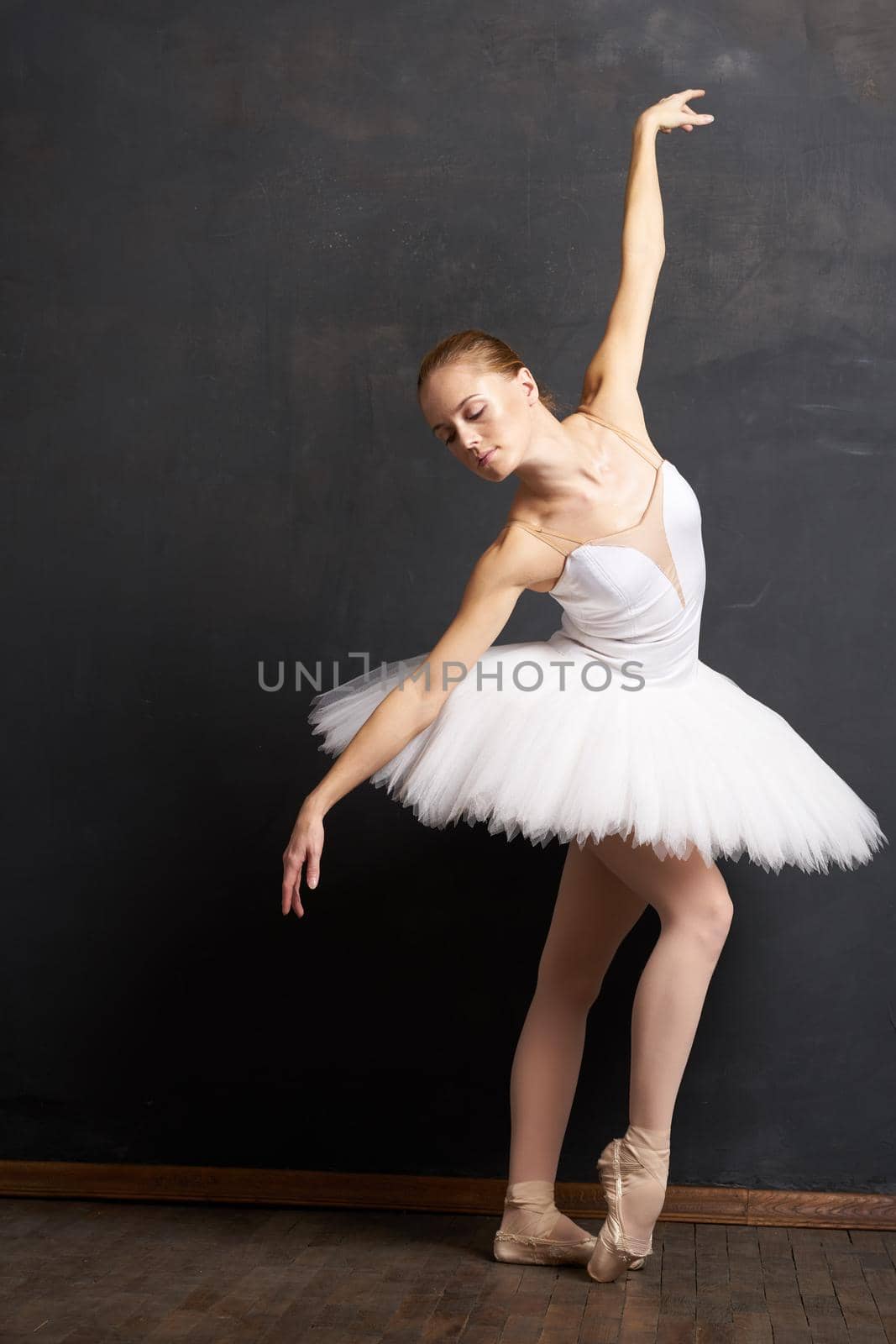 woman ballerina in a white tutu dance posing performance dark background. High quality photo