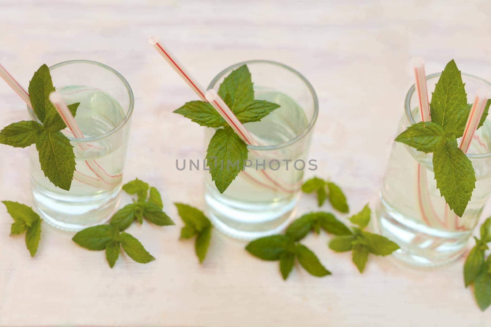 Set of Summer healthy homemade mint lemonade infused water drink, mint leaves in glass on grey background. Close up mojito coctail. Selective focus. by julija