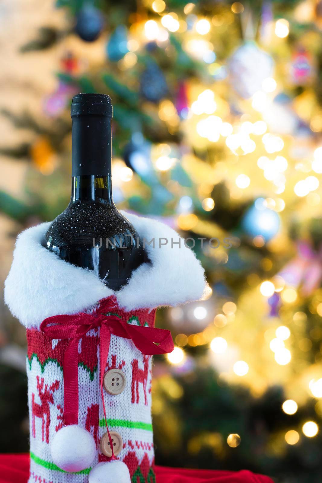 Luxurious holiday composition, a bottle wine with a Christmas tree and bokeh lights on the background with copy space, Holiday concept space for text