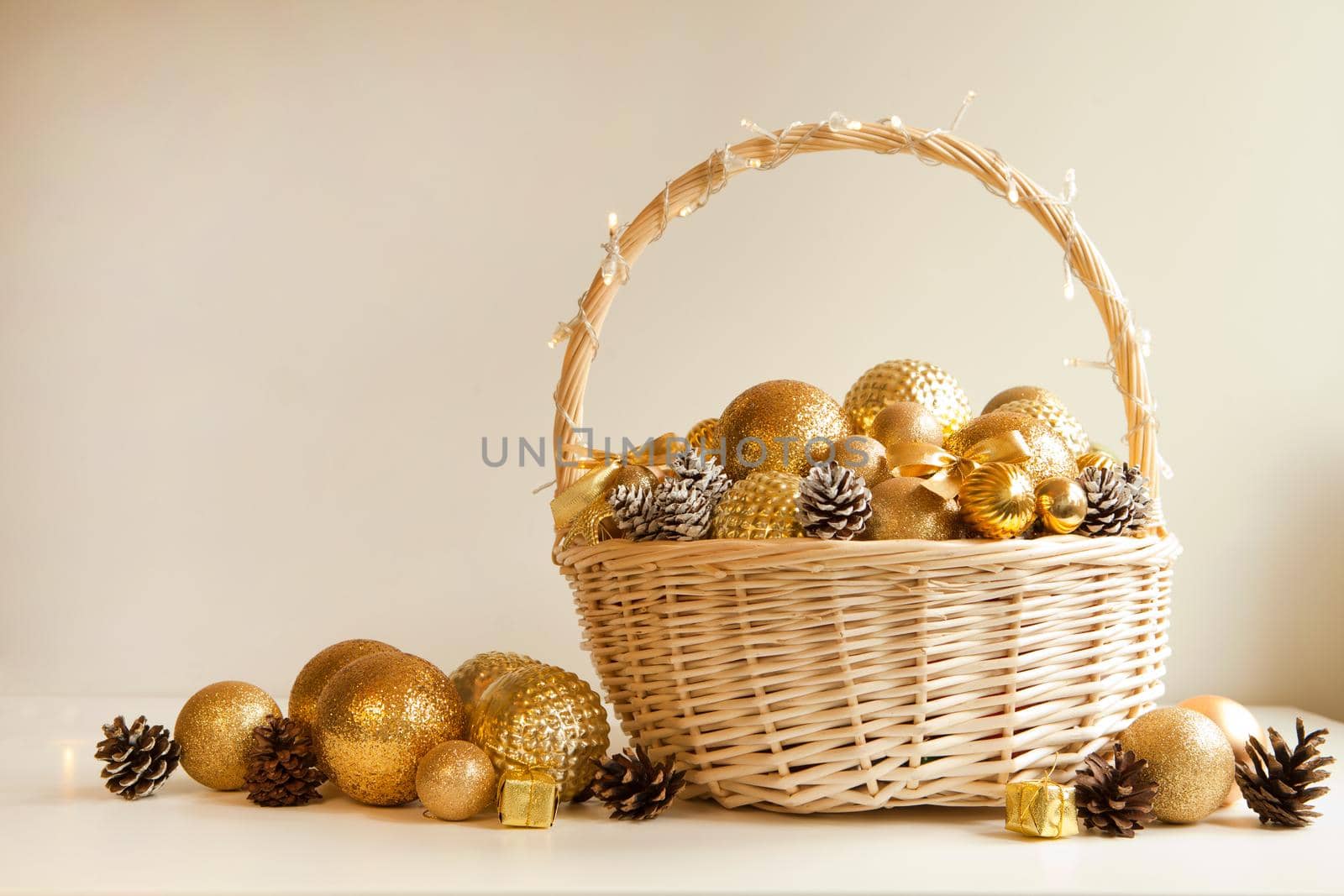 huge white basket with golden balls and pine cones for fir decoration. Christmas preparations. wicker filled to the top with golden balls to decorate Christmas tree or apartment