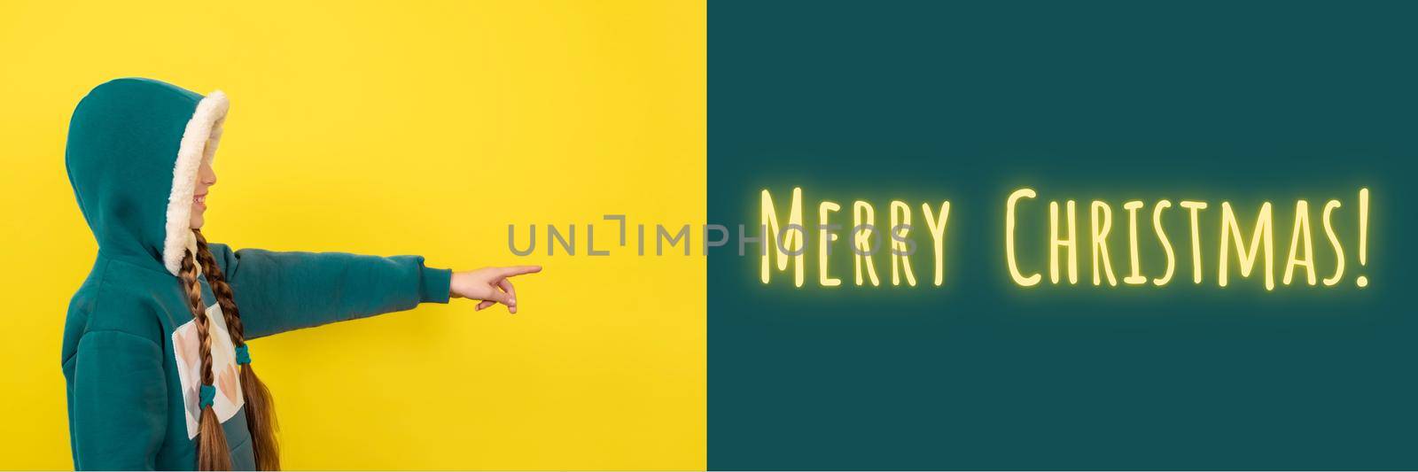 Teen beautiful girl pointing her finger on merry christmas. Banner with copy space. New year or christmas concept banner