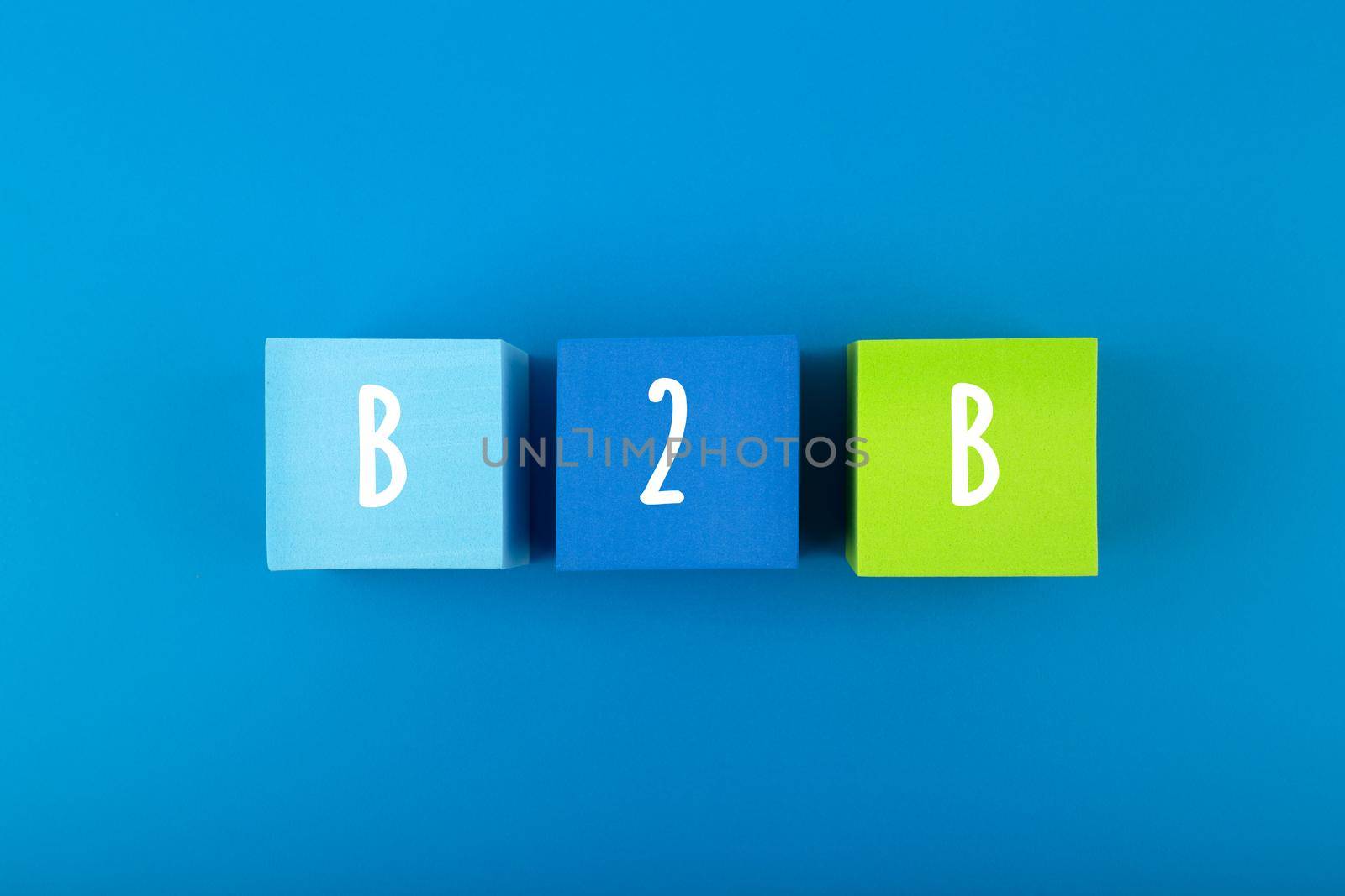 B2B minimal commercial marketing business concept. B2B letters written on multicolored cubes in a row against dark blue background