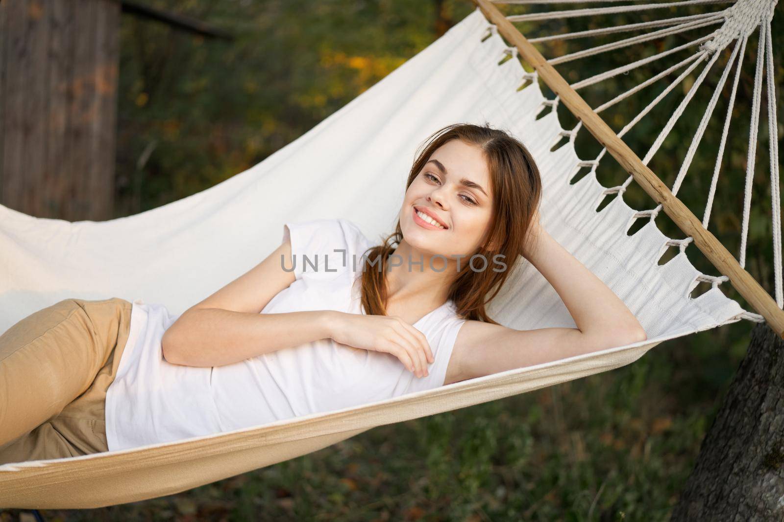 cheerful woman lies in a hammock rest nature fresh air by Vichizh